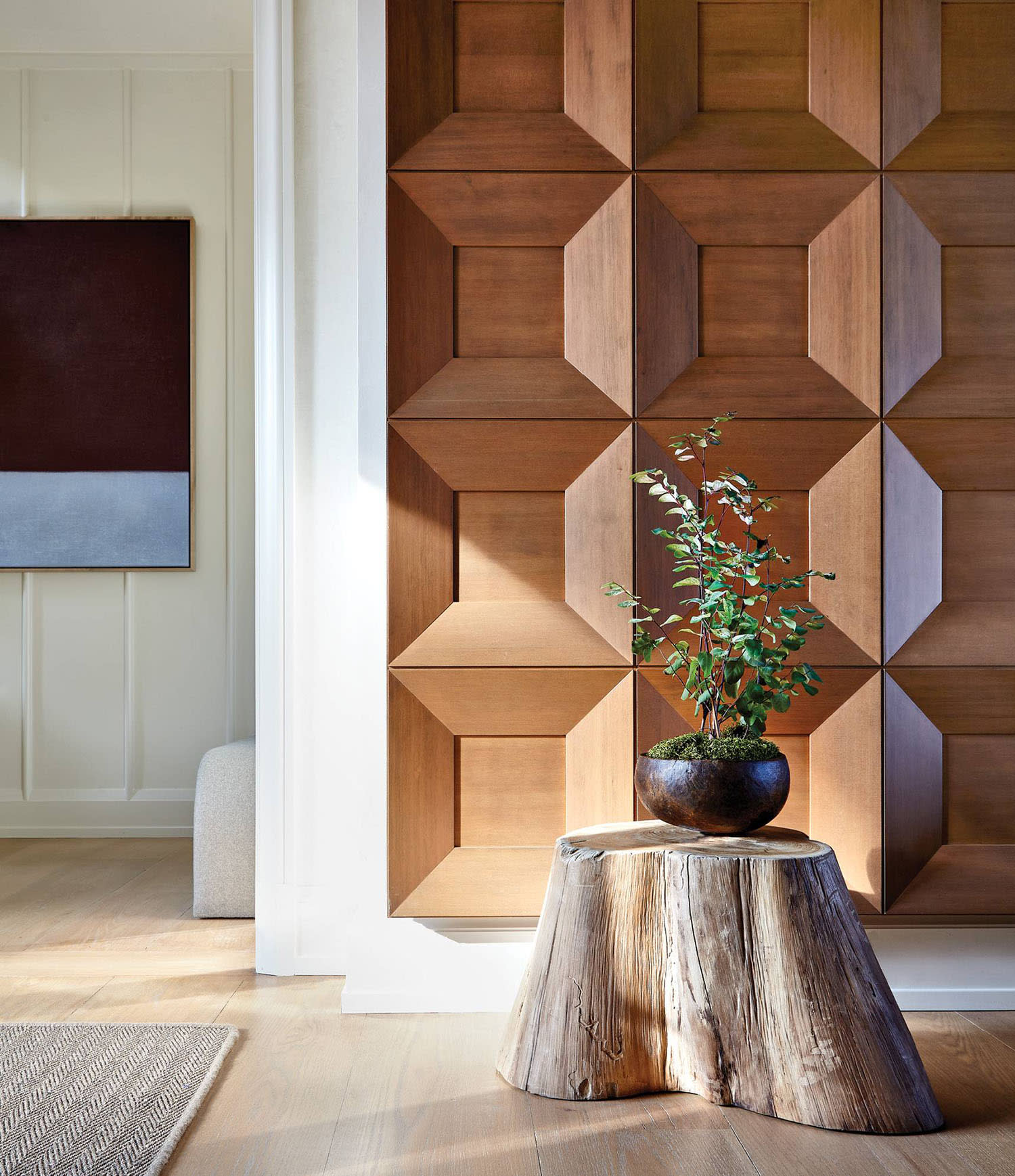 A band of wire-brushed Douglas fir wall panels and a tree-stump table in a foyer