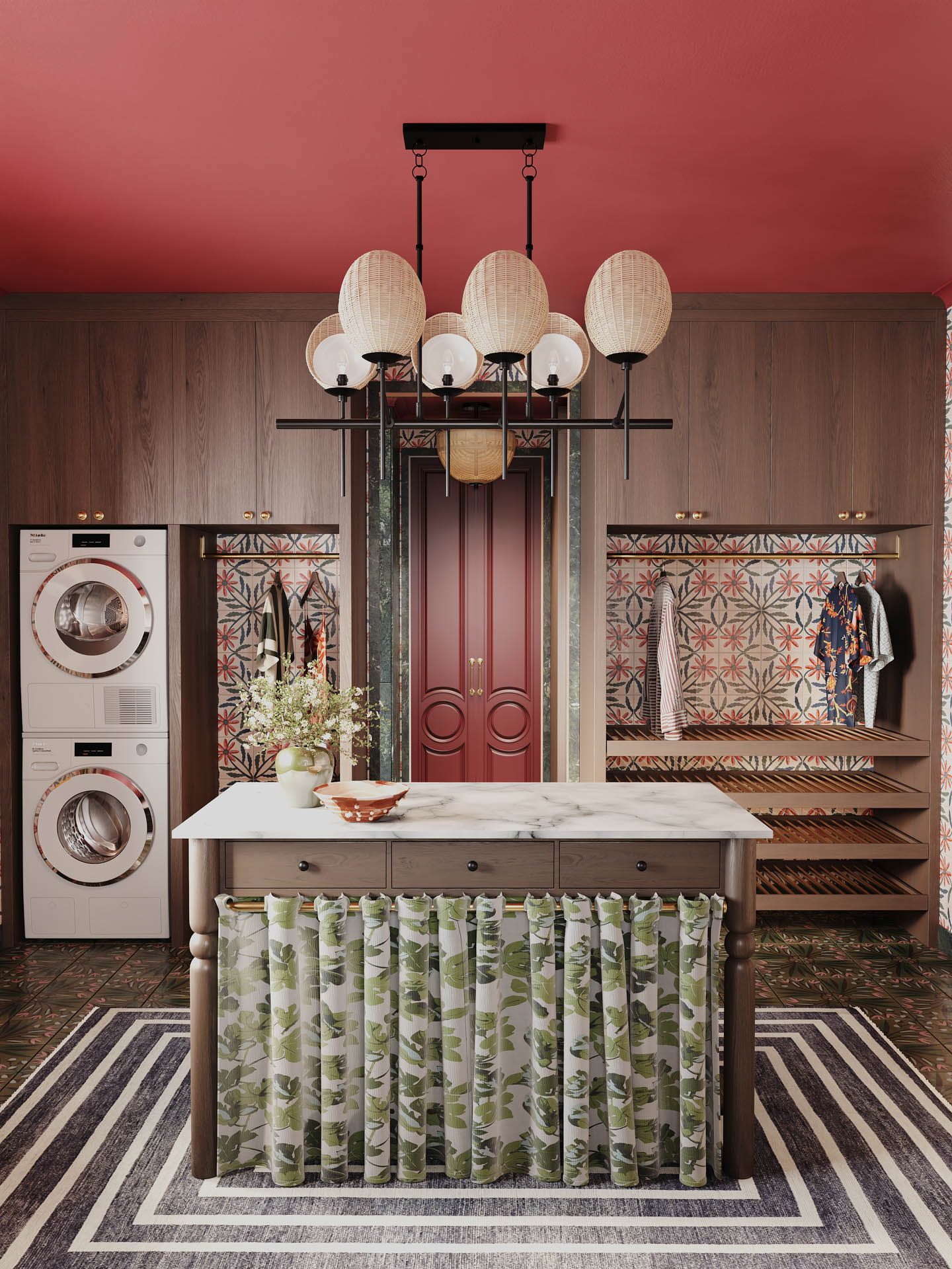 Stylish laundry room featuring red walls, patterned tiles, and a modern washer-dryer. A center island with floral curtains and elegant lighting adds charm.