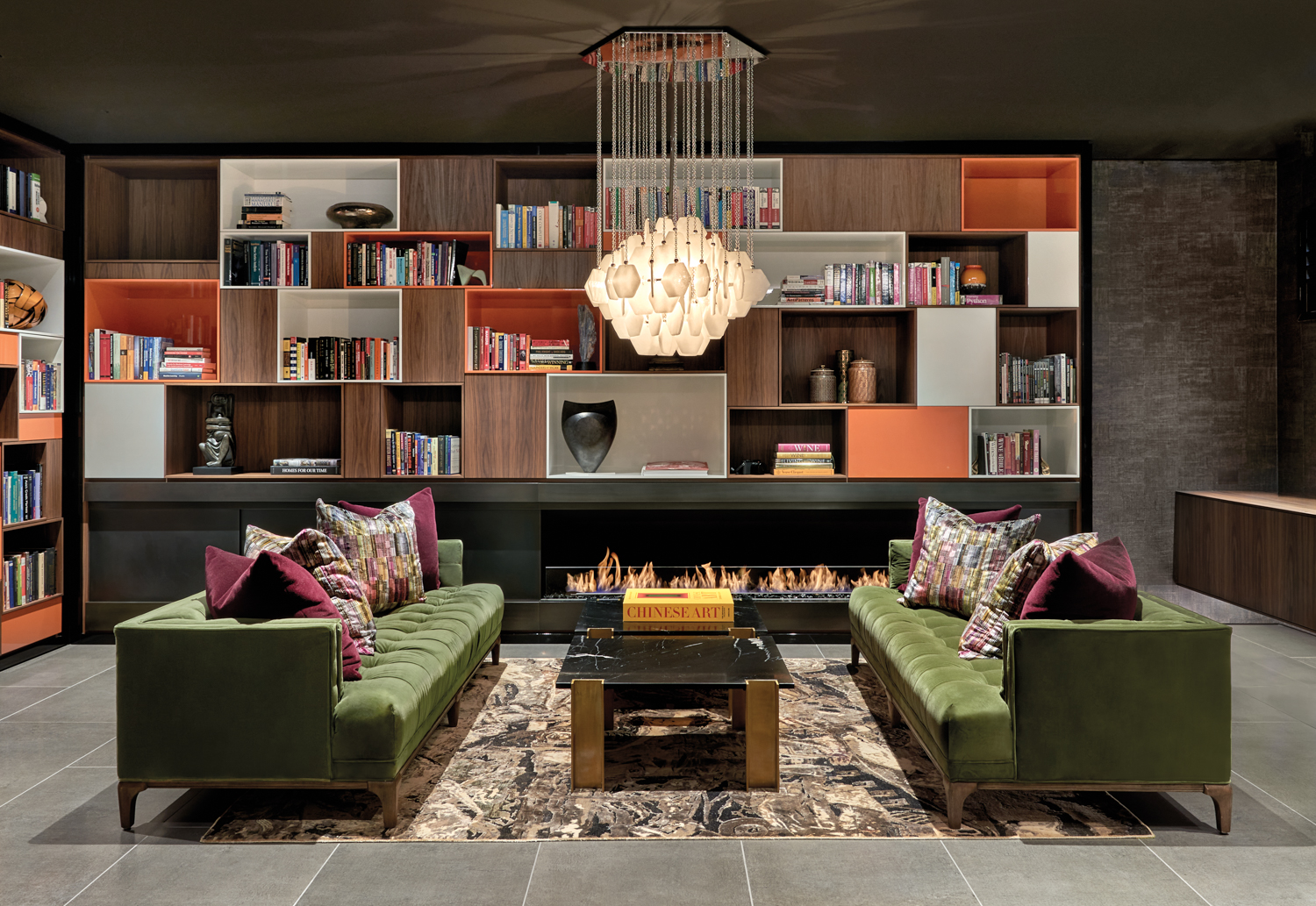 basement midcentury modern lounge with built-in shelving and a pair of green sofas on either side of black marble coffee table