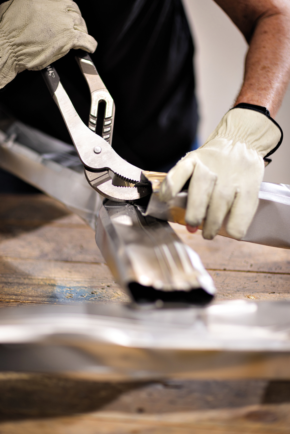 an artist using tools to bend metal