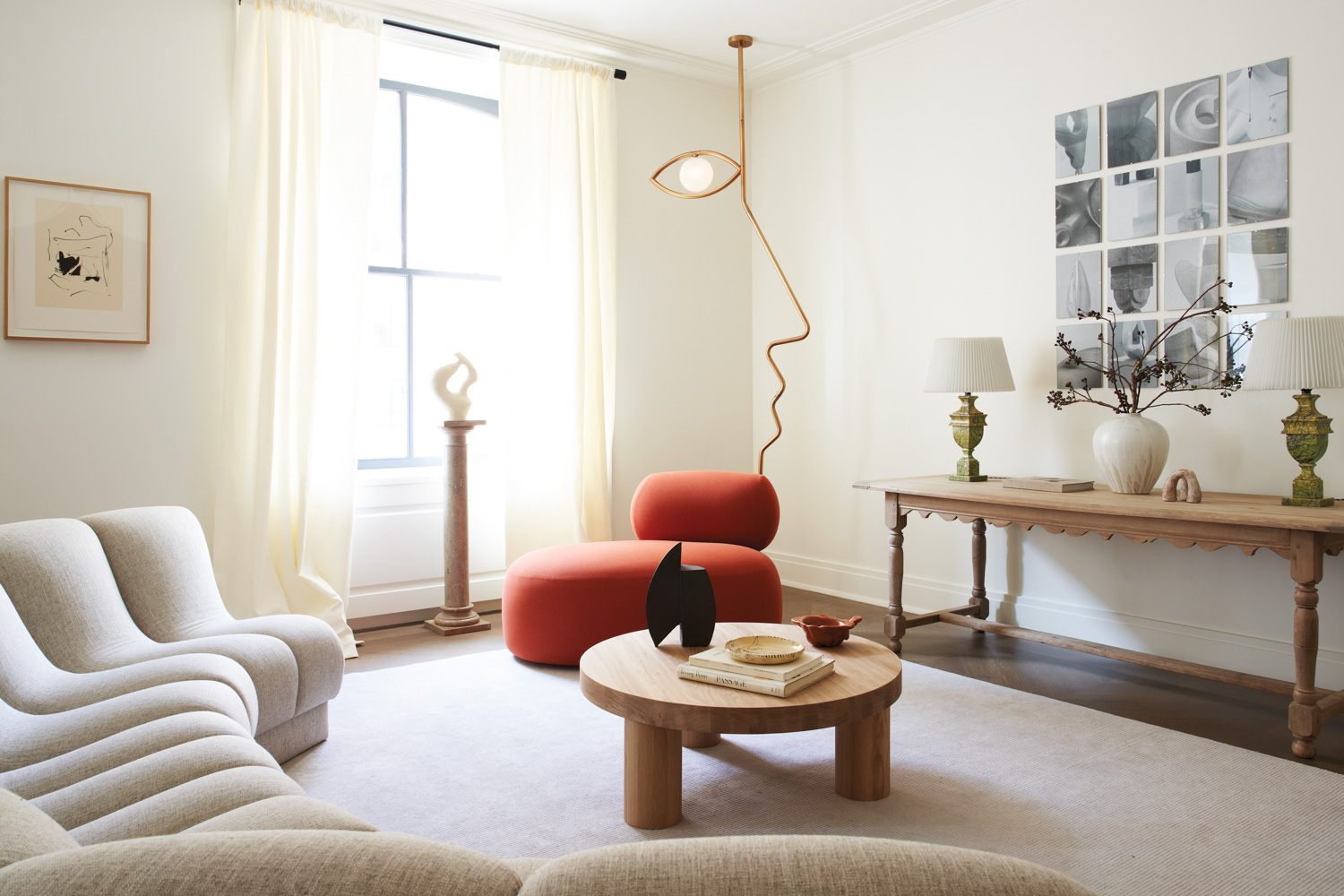 Modern living room with wood coffee table, red lounge chair and face sculpture