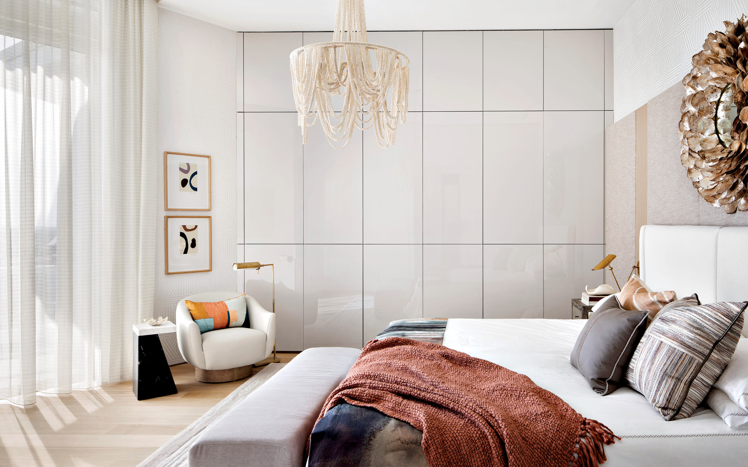 contemporary bright bedroom with sheer curtains and a boho-style chandelier