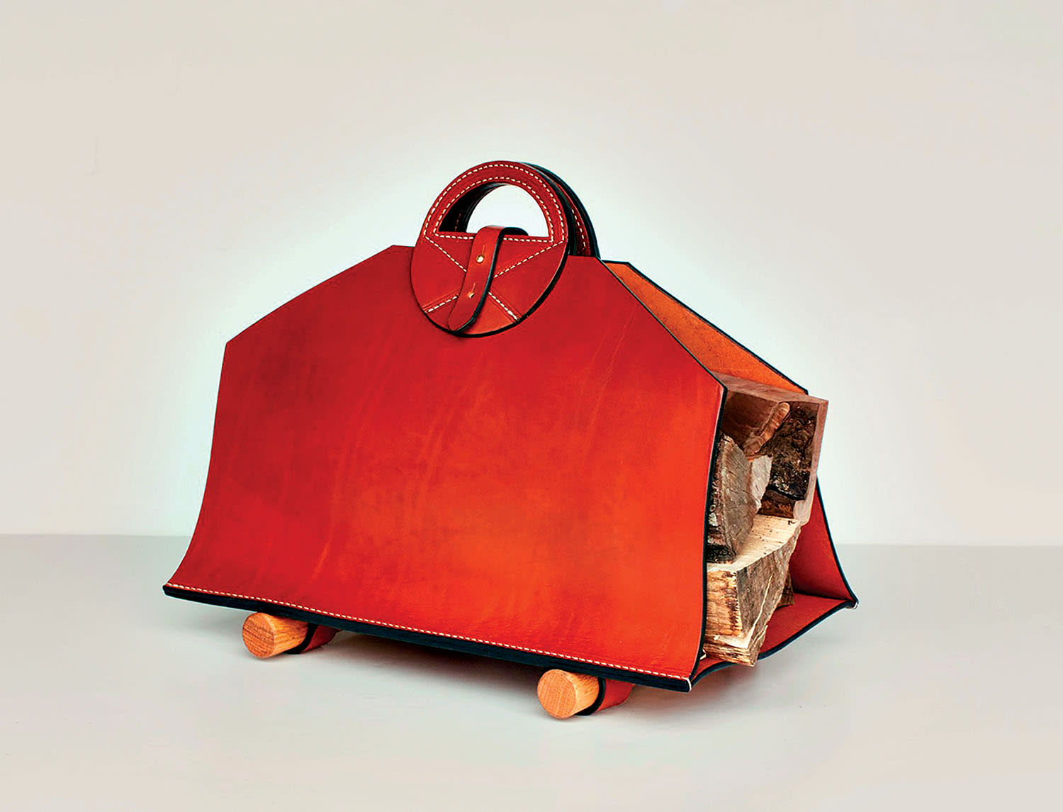 A red metal firewood carrier filled with wood.