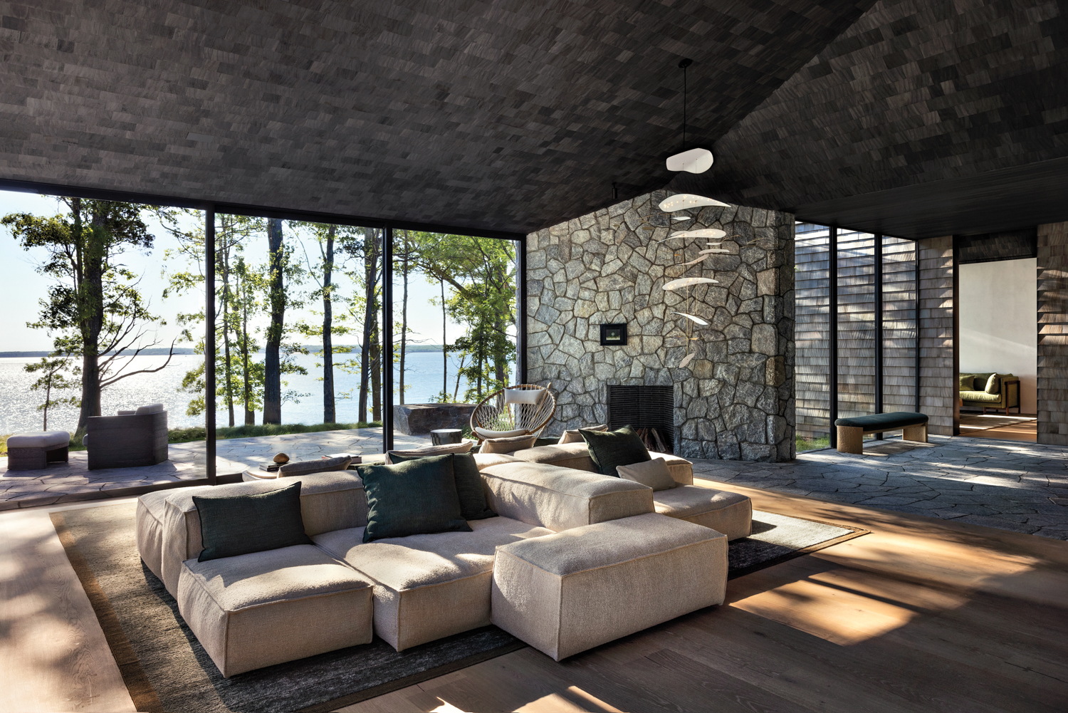 cozy living room with a stone fireplace and beige sectional