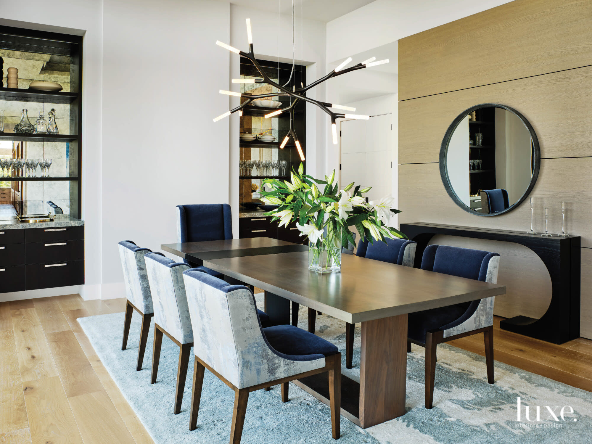 A dining room features a sculptural light fixture and a long table.