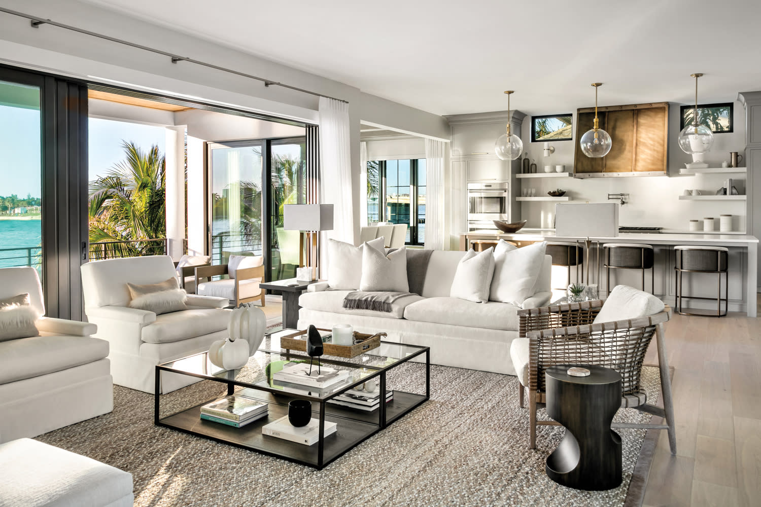 neutral-toned living area with glass square coffee table, white sofa and textured rug