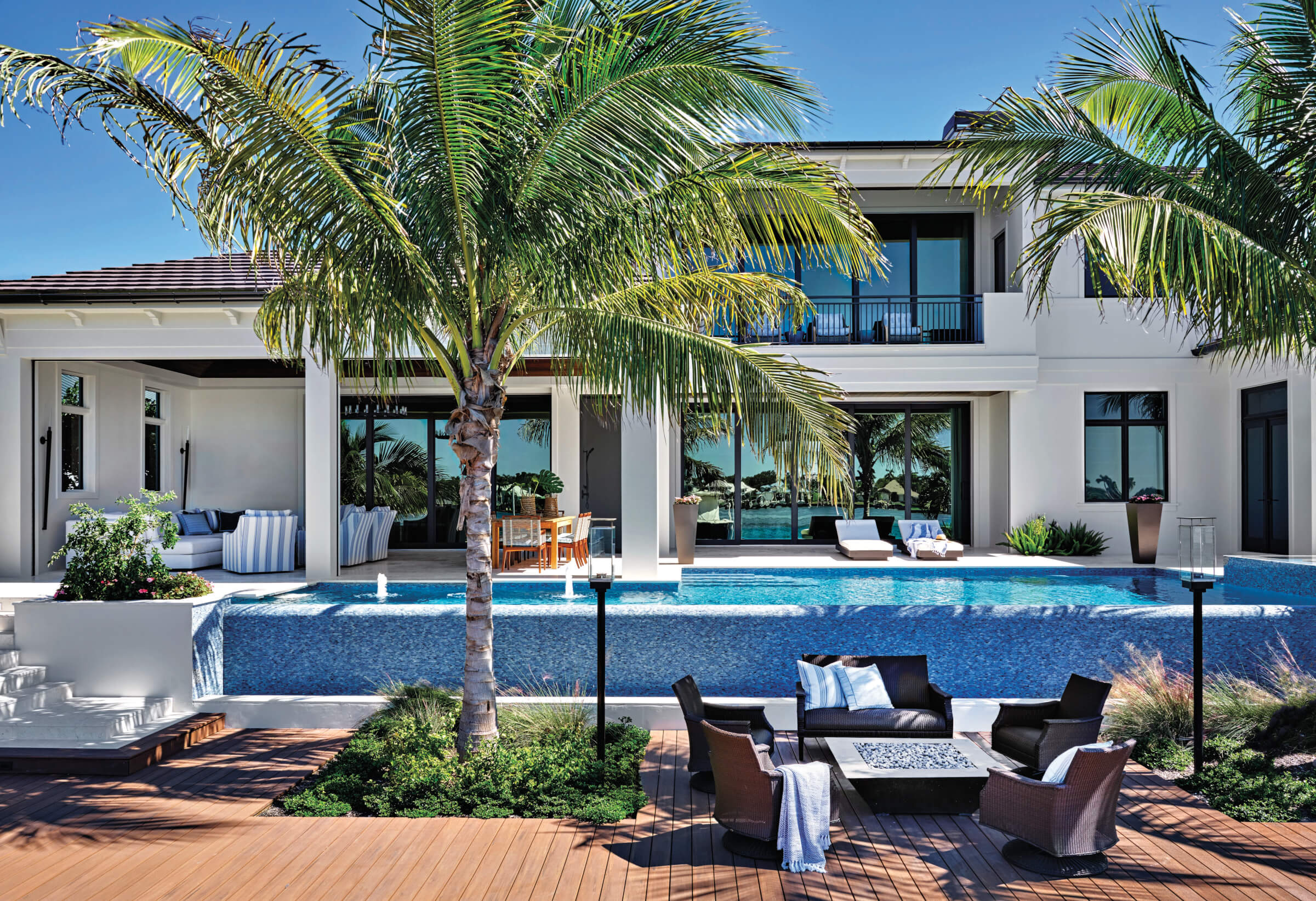 backyard exterior of naples home with pool outdoor seating and fire pit 