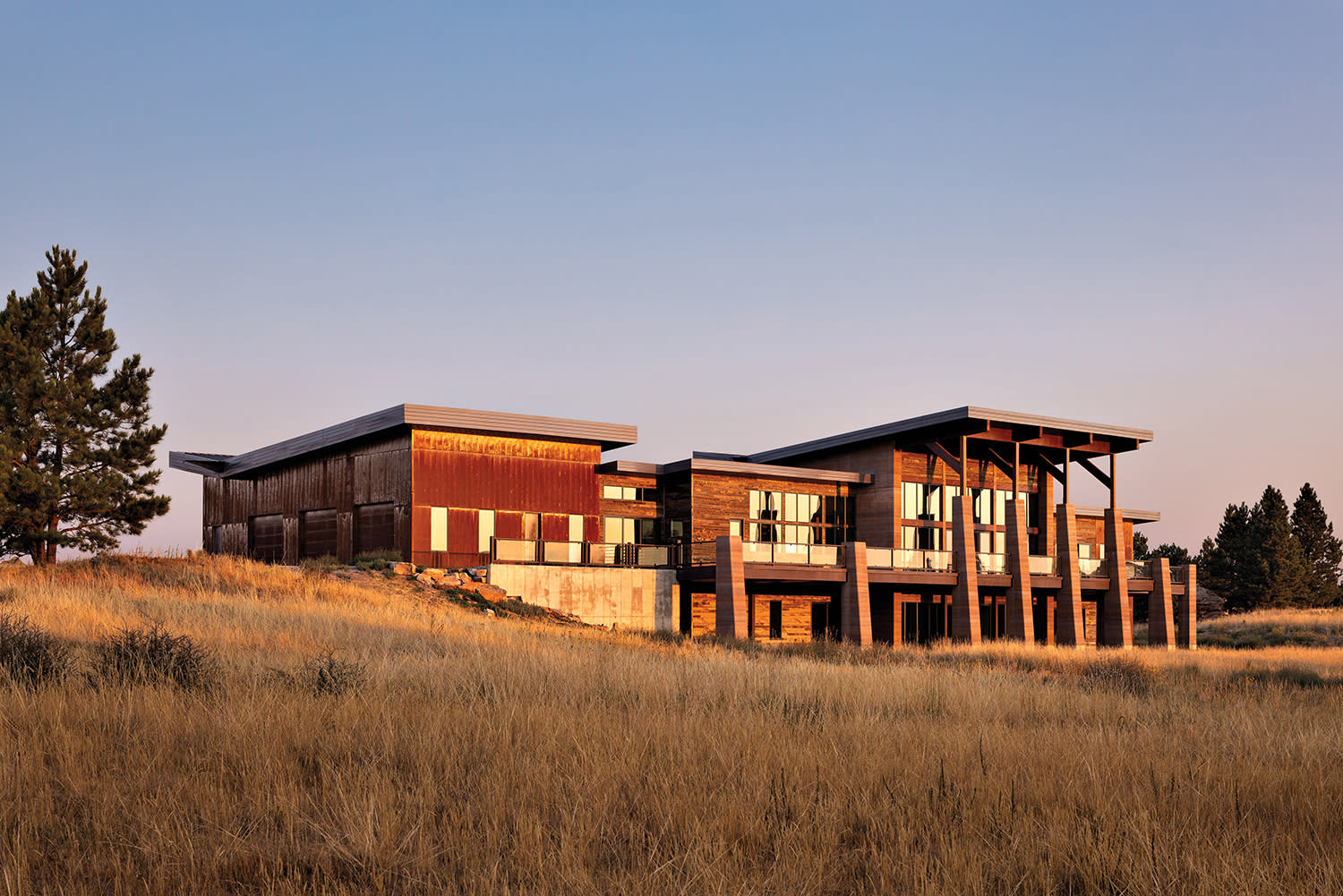 exterior of a Wyoming home with oxidized Corten steel, reclaimed-wood siding & rammed-earth columns
