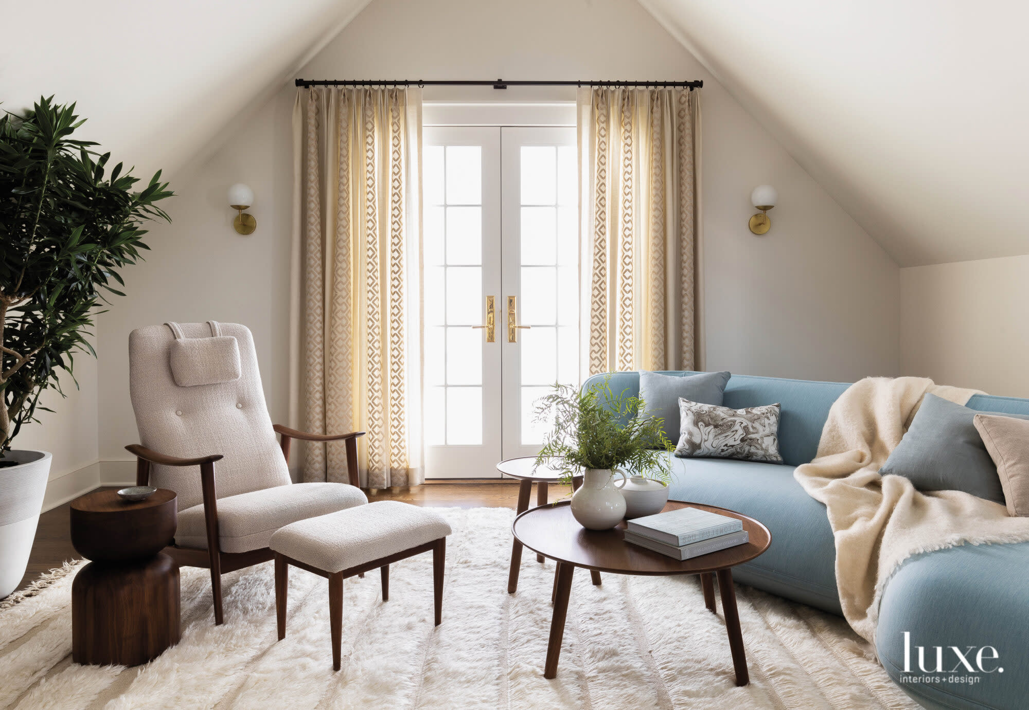 Family room with modern furniture and a large window, flooding the space with light.