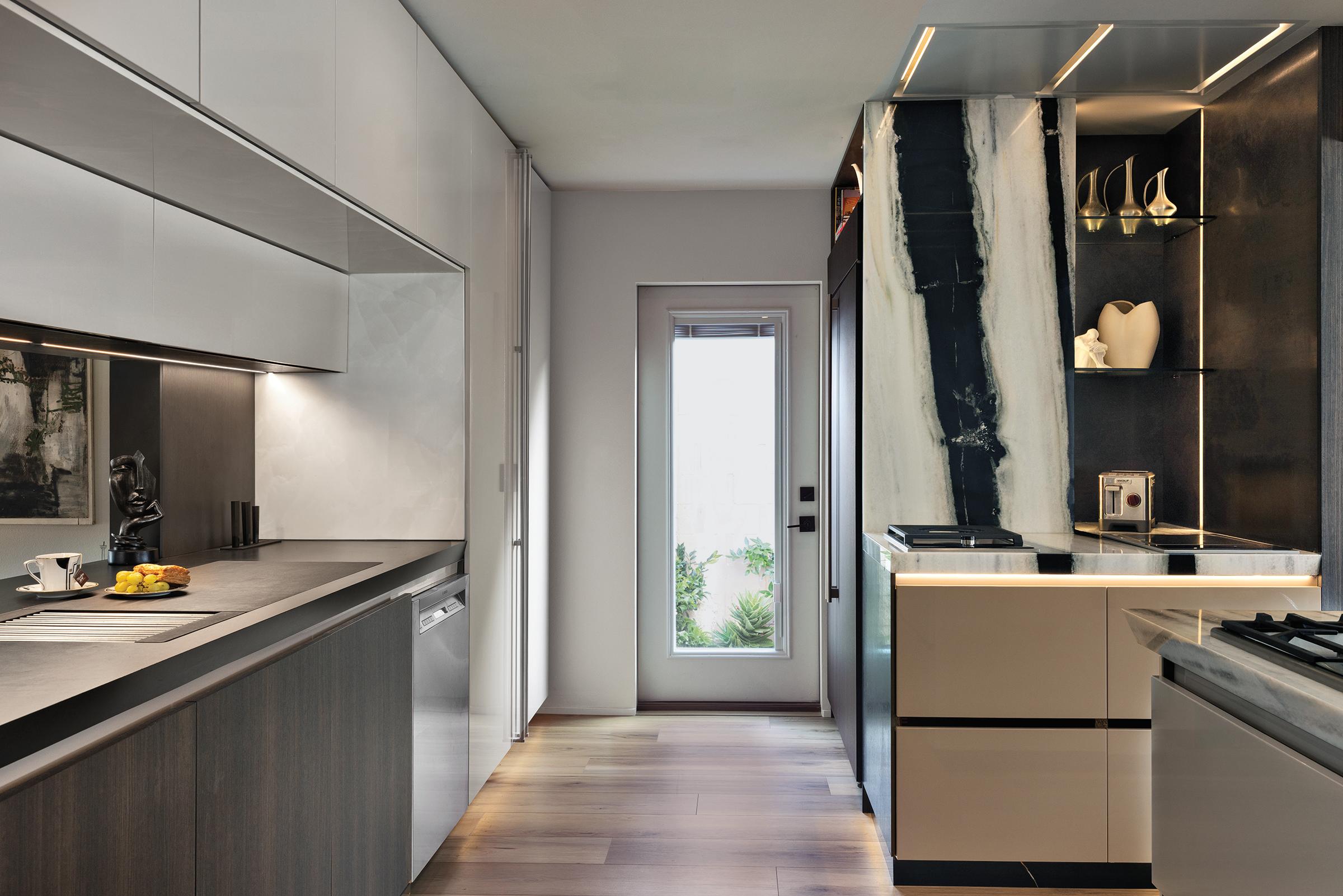 JennAir NOIR™ appliances installed in the Pazzam Project kitchen, with sleek black glass fronts integrated flush within custom cabinetry for a clean architectural elevation.