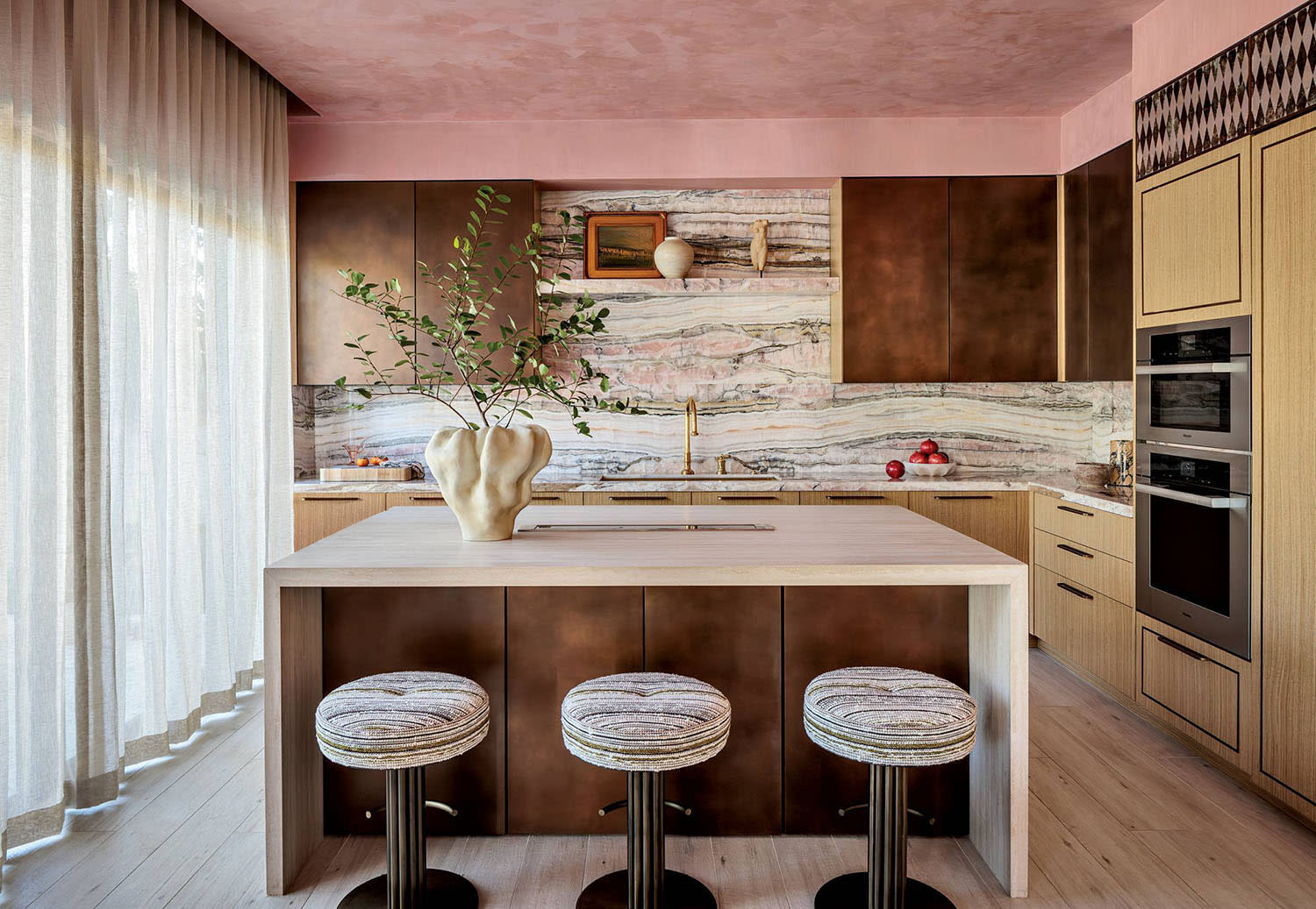 maximalist kitchen with a pink ceiling and onyx backsplash