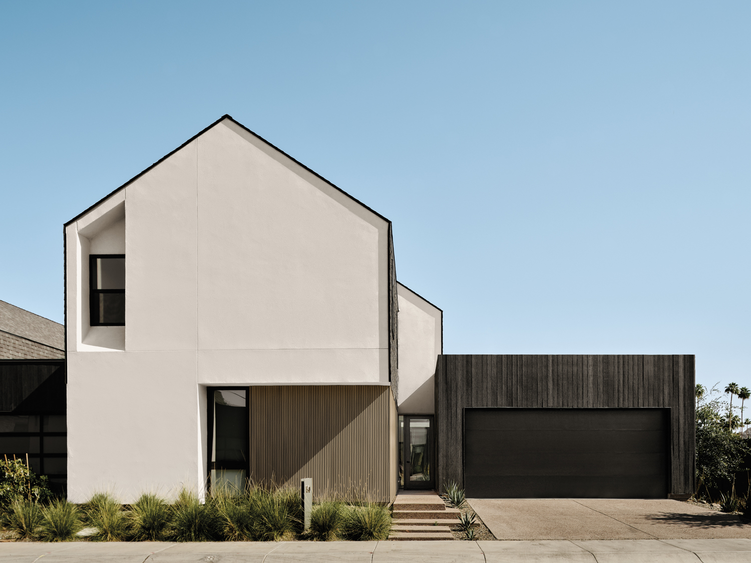 Exterior of a cream-colored house with dark wood-paneled garage