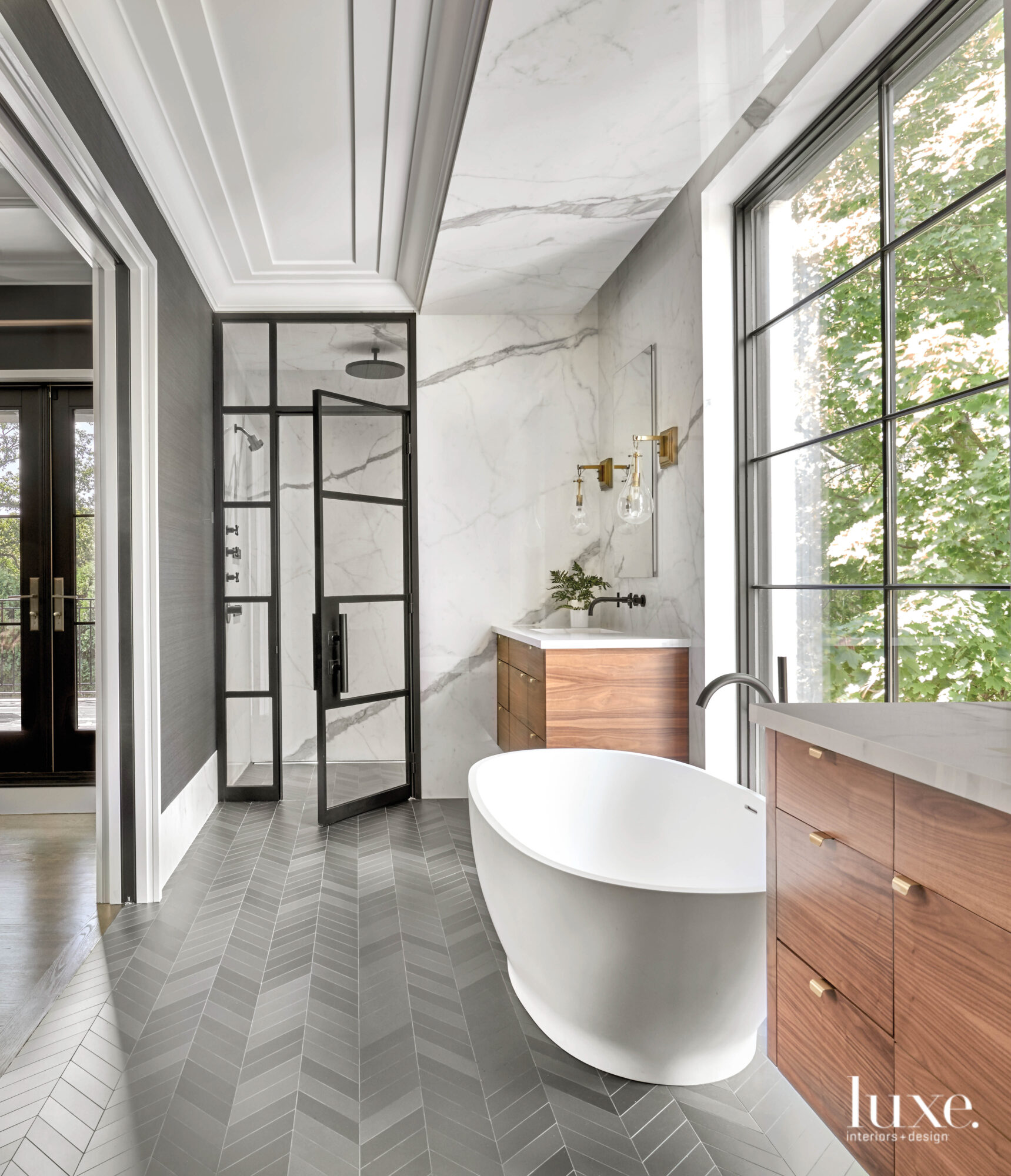 A free-standing tub sits in front of a floor-to-ceiling window in the homeowners' bathroom.