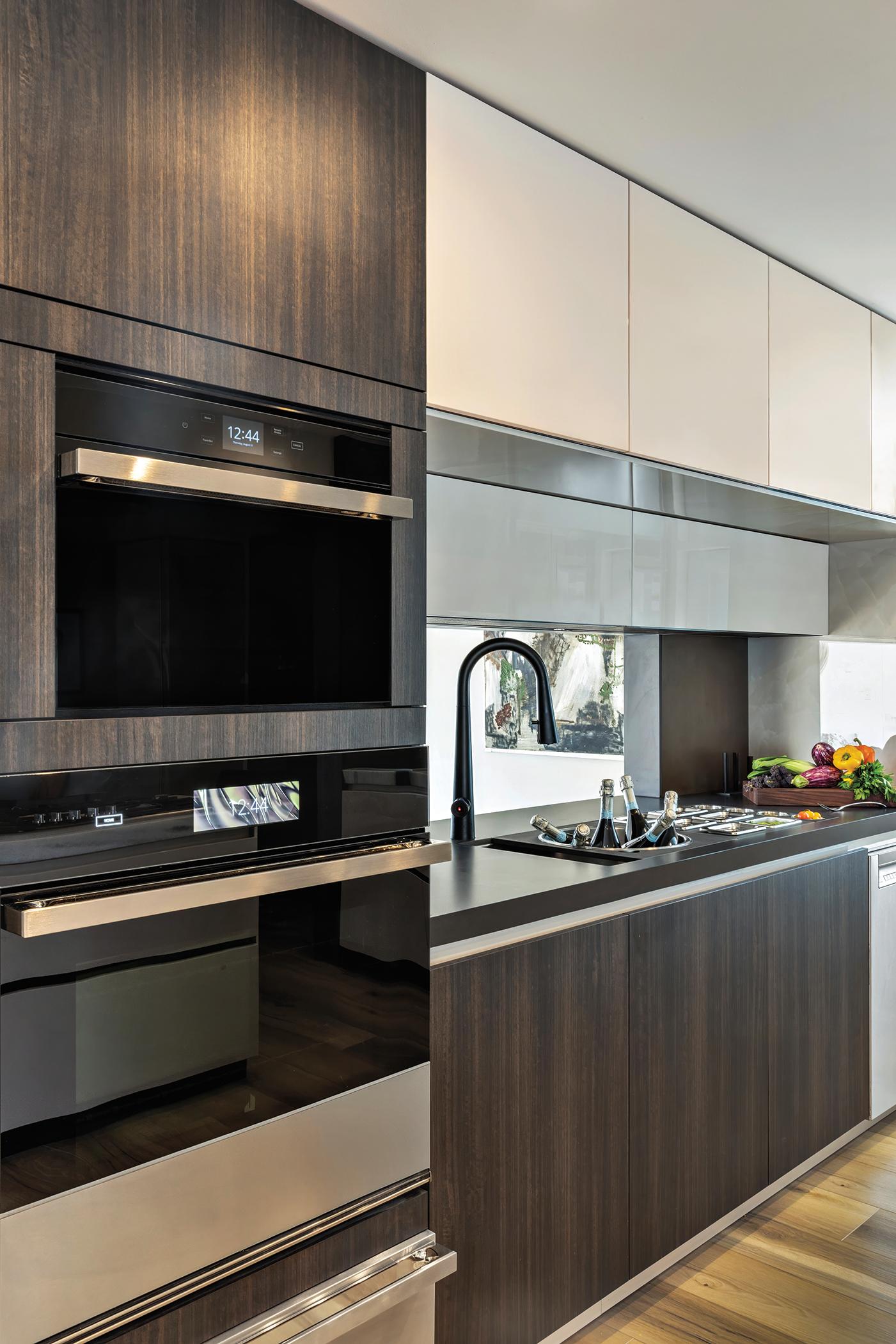 JennAir NOIR™ appliances installed in the Pazzam Project kitchen, with sleek black glass fronts integrated flush within custom cabinetry for a clean architectural elevation.