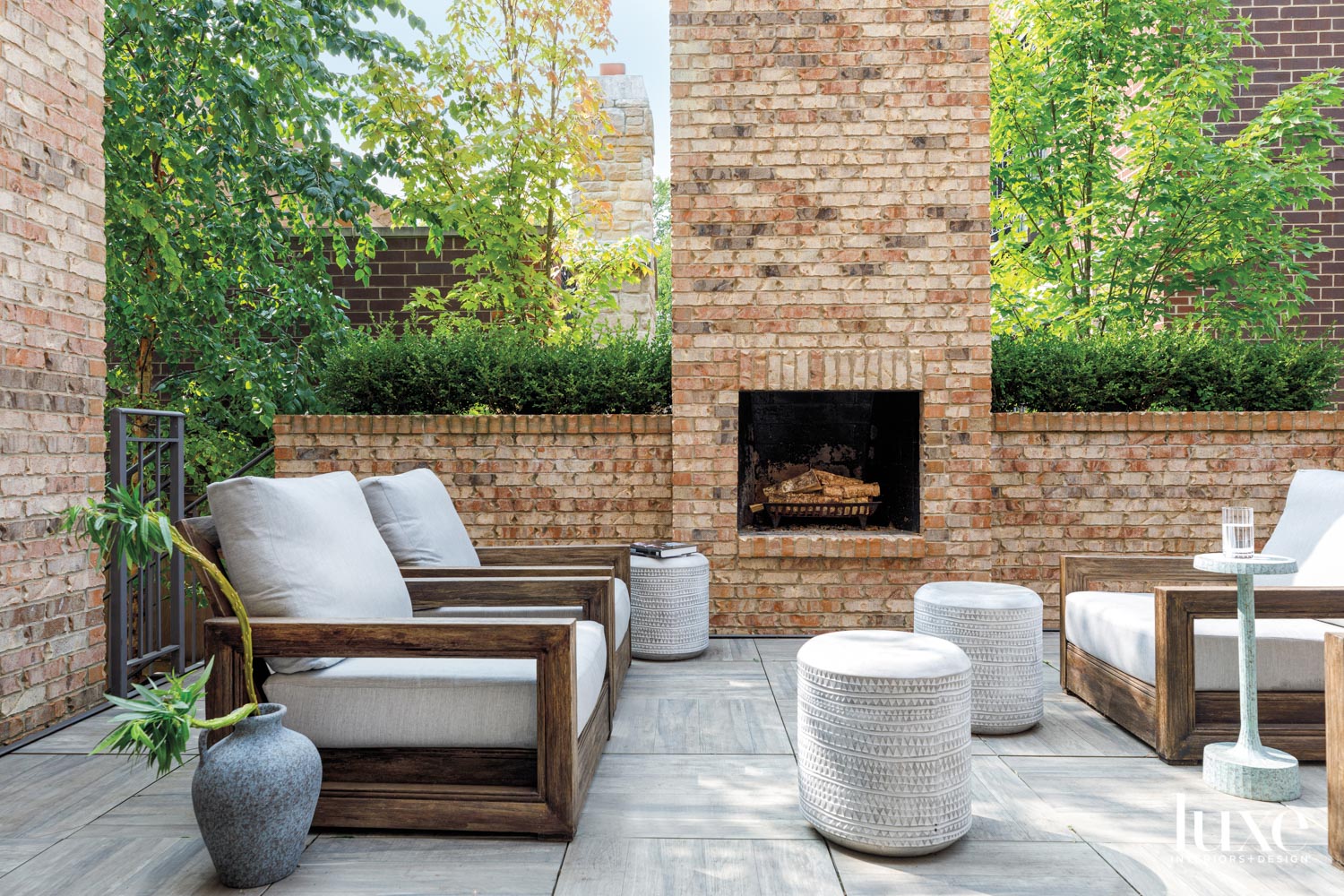 A seating area surrounding a brick outdoor fireplace.