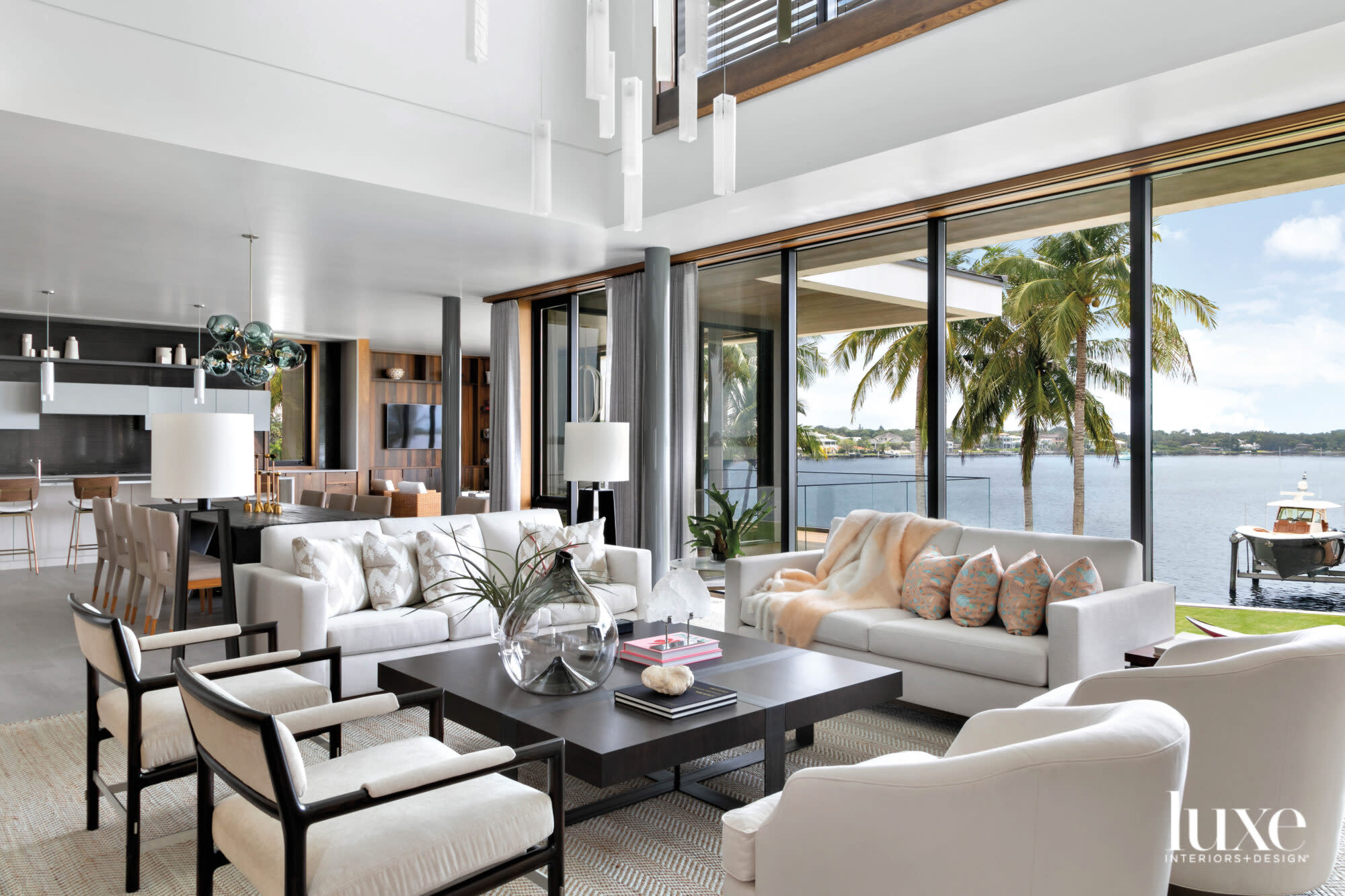 Living room with white furnishings and a wall of windows.