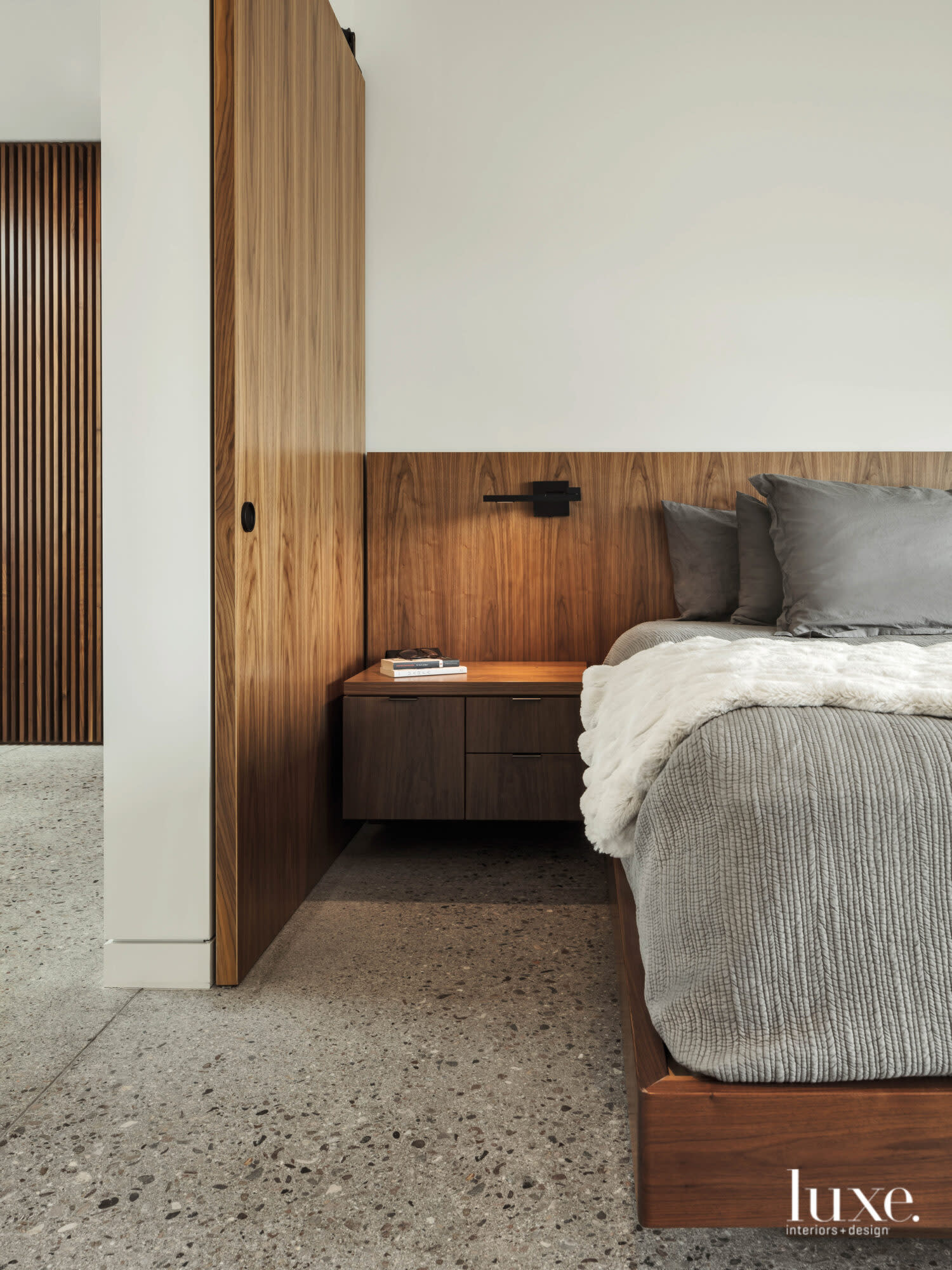 The homeowners' minimalist bedroom centers around a built-in bed with integrated side tables.