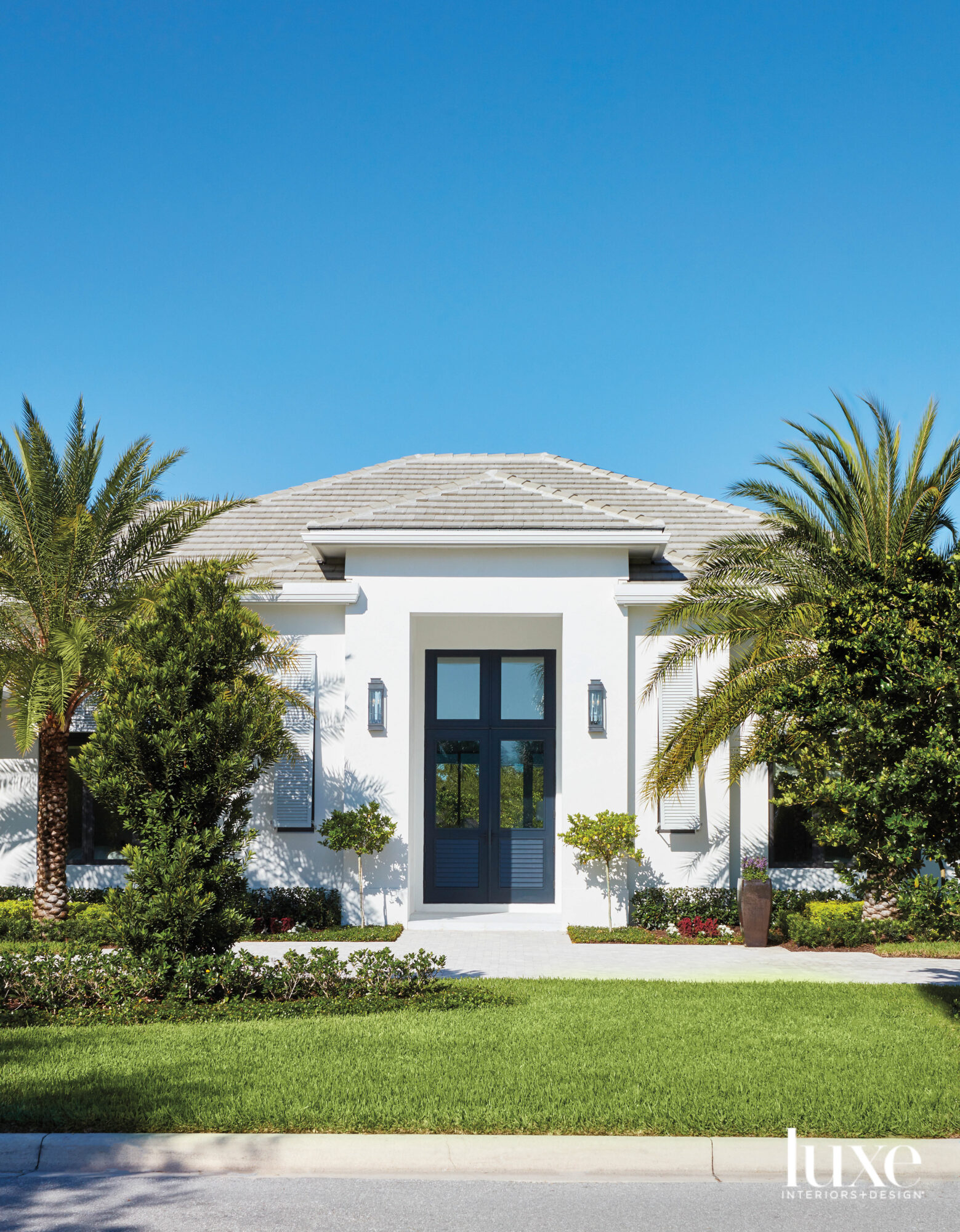 one-story house with white stucco exterior and palm trees