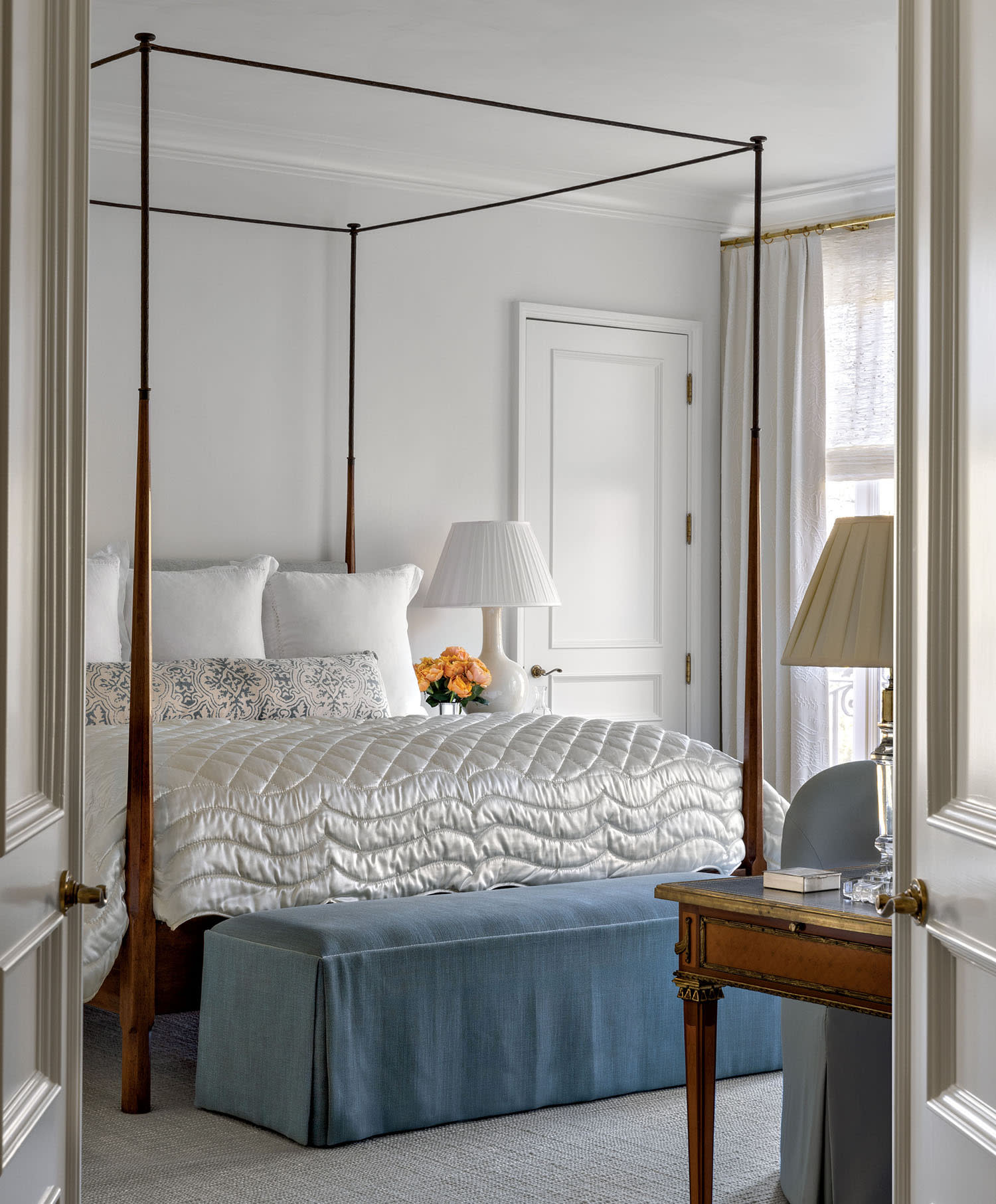 cozy, traditional bedroom with a canopy bed and lush, white fabrics