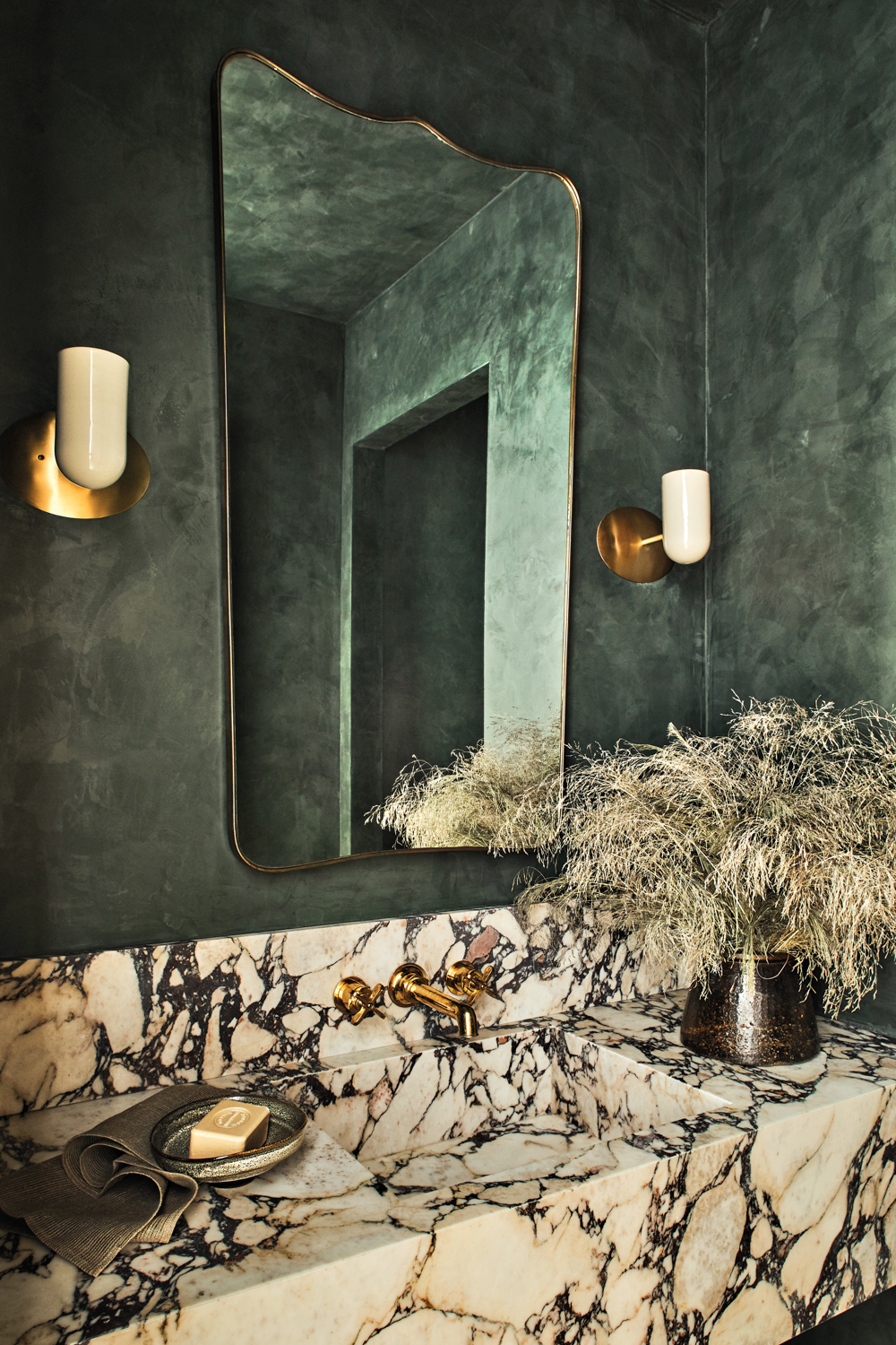 A moody green bathroom by Studio Life/Style features a calacatta viola marble