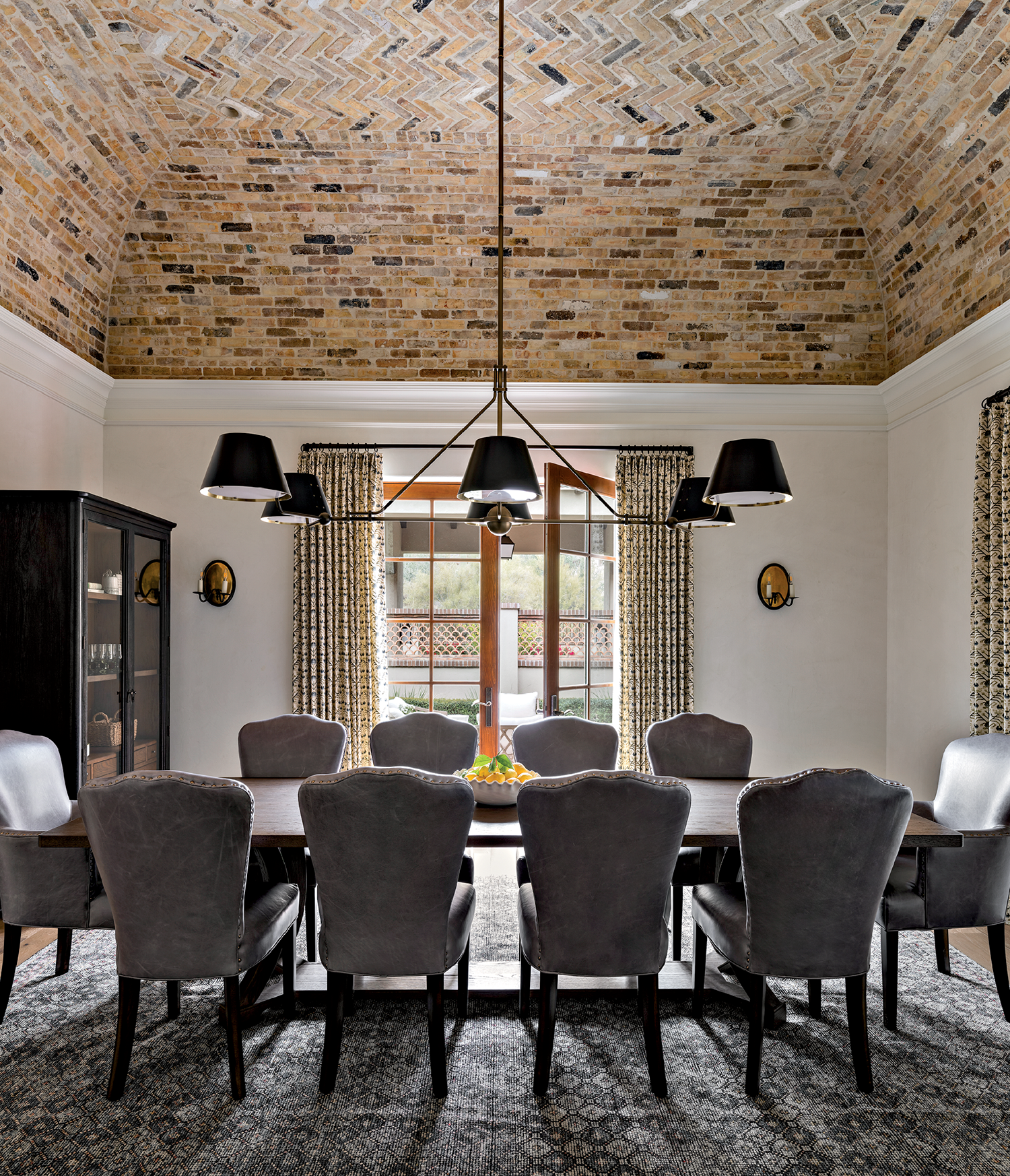 Elegant dining room with a large table and ten gray upholstered chairs