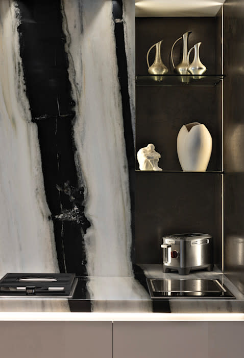 Sculptural stone island in the Pazzam Project fabricated by Cornerstone Granite Design, showcasing a dramatic waterfall edge and precision slab layout.