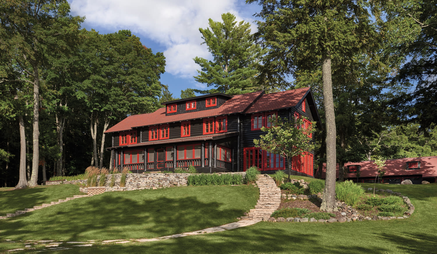 log cabin with red trip surrounded by trees