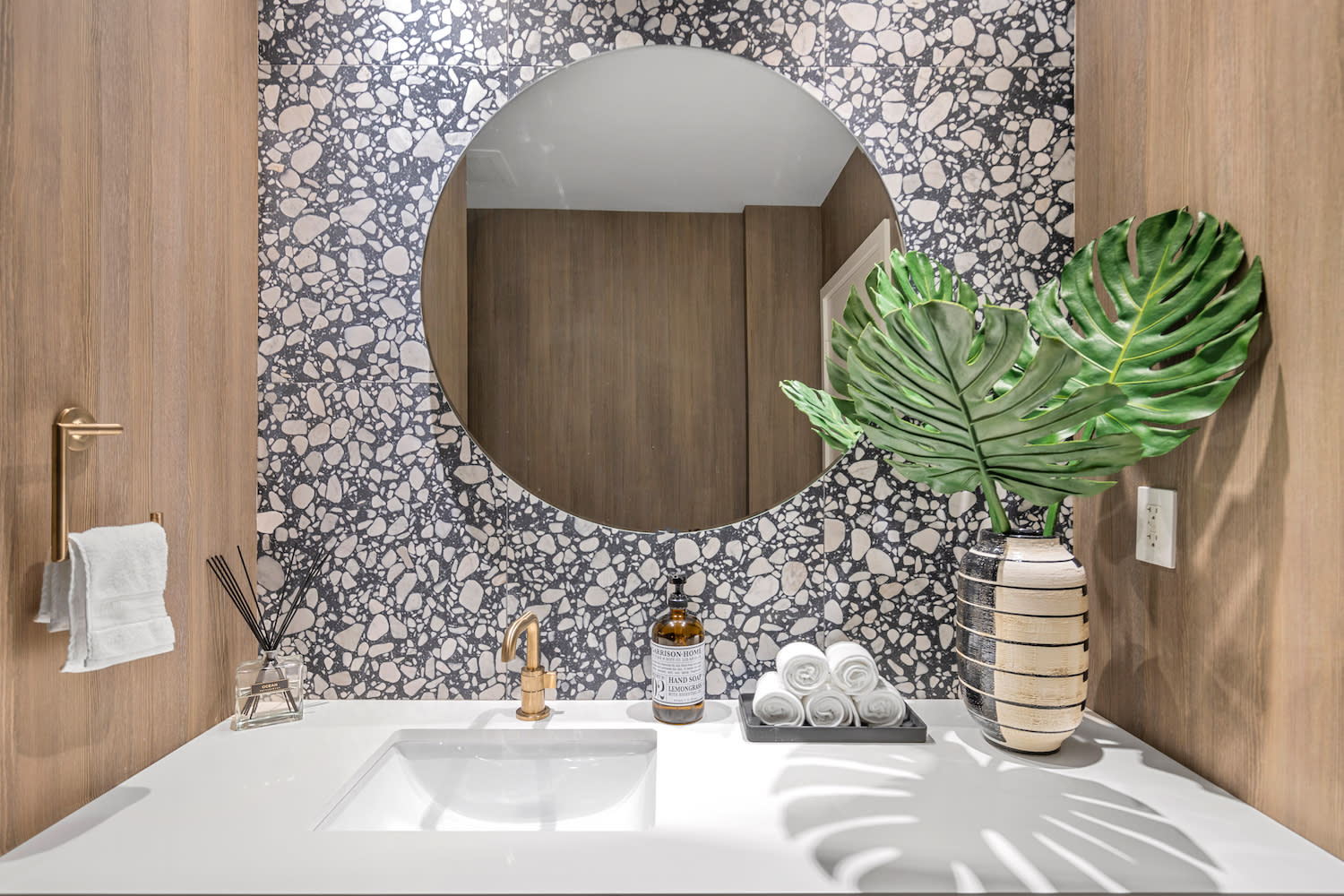 powder room vanity featuring terrazzo backsplash