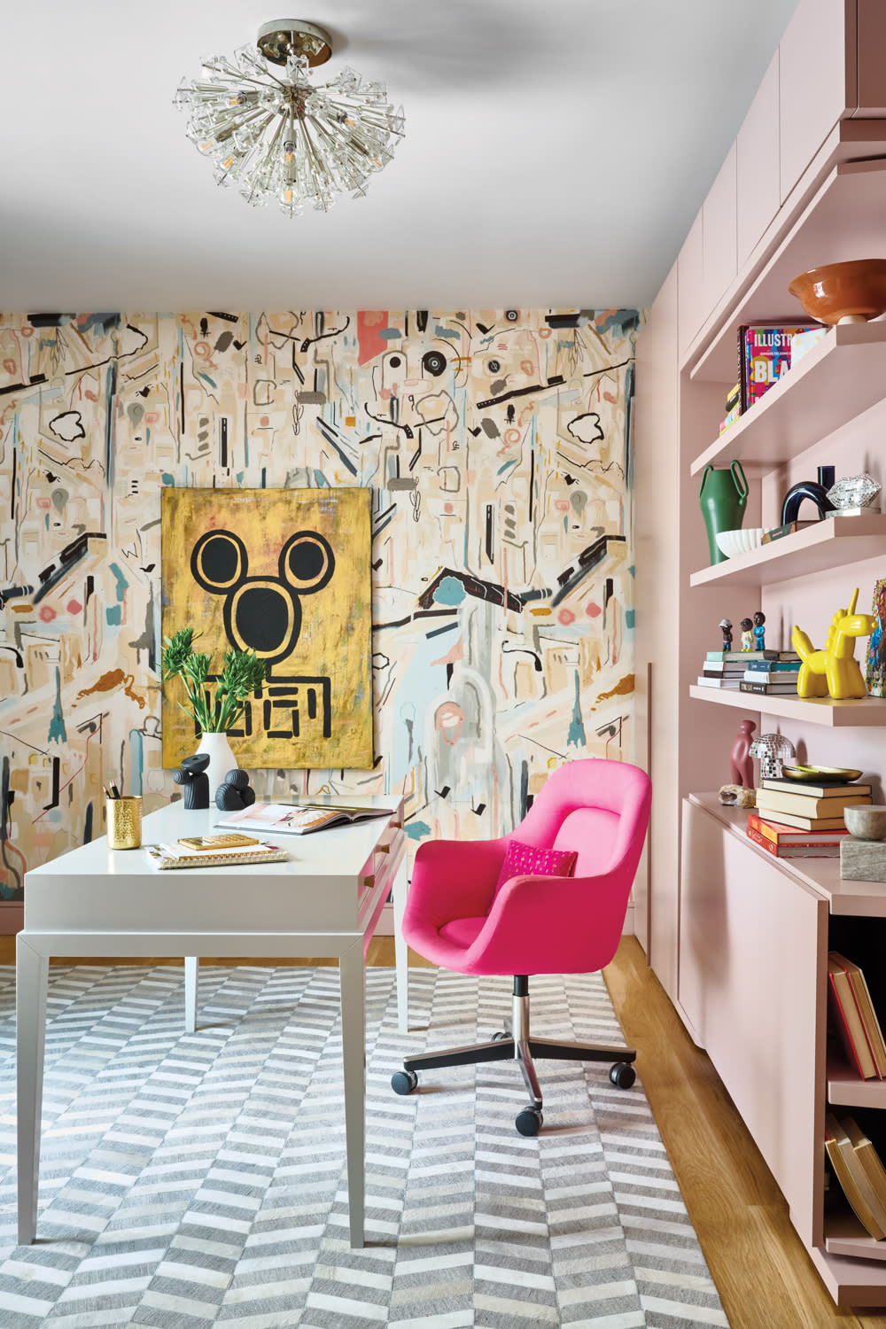 modern home office with graphic wallpaper, pink casewood, bright pink chair and a white desk
