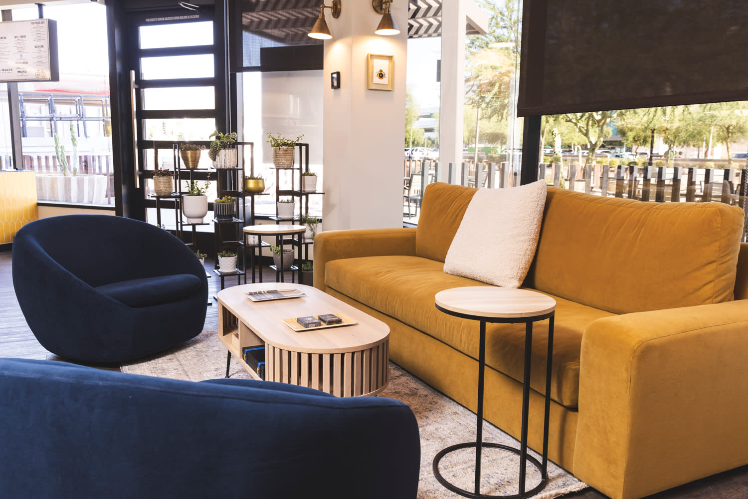 Seating area with mustard-colored sofa and navy arm chairs around wood coffee table.