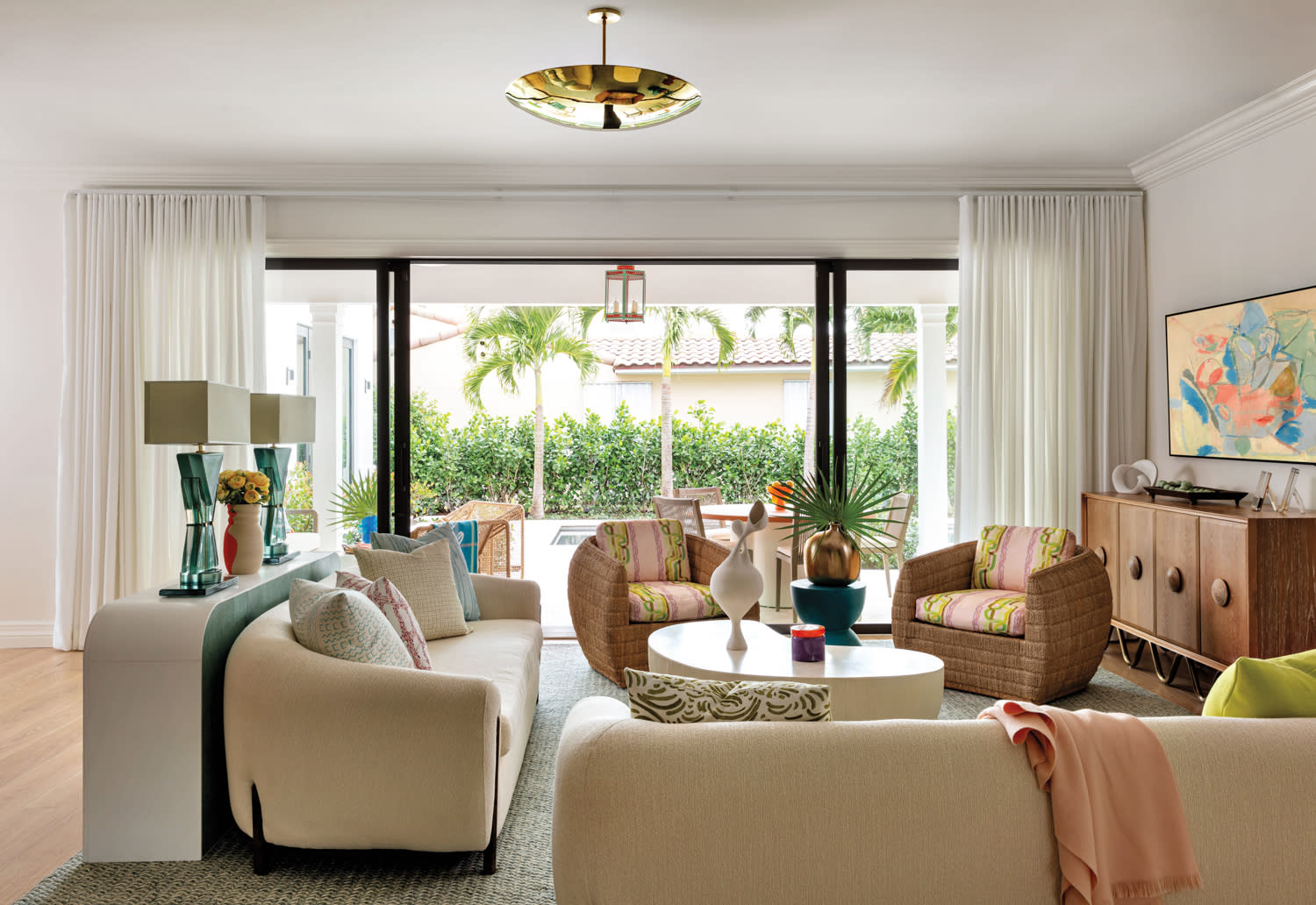 living area with gold pendant, woven textures and curved sofas, armchairs and coffee table