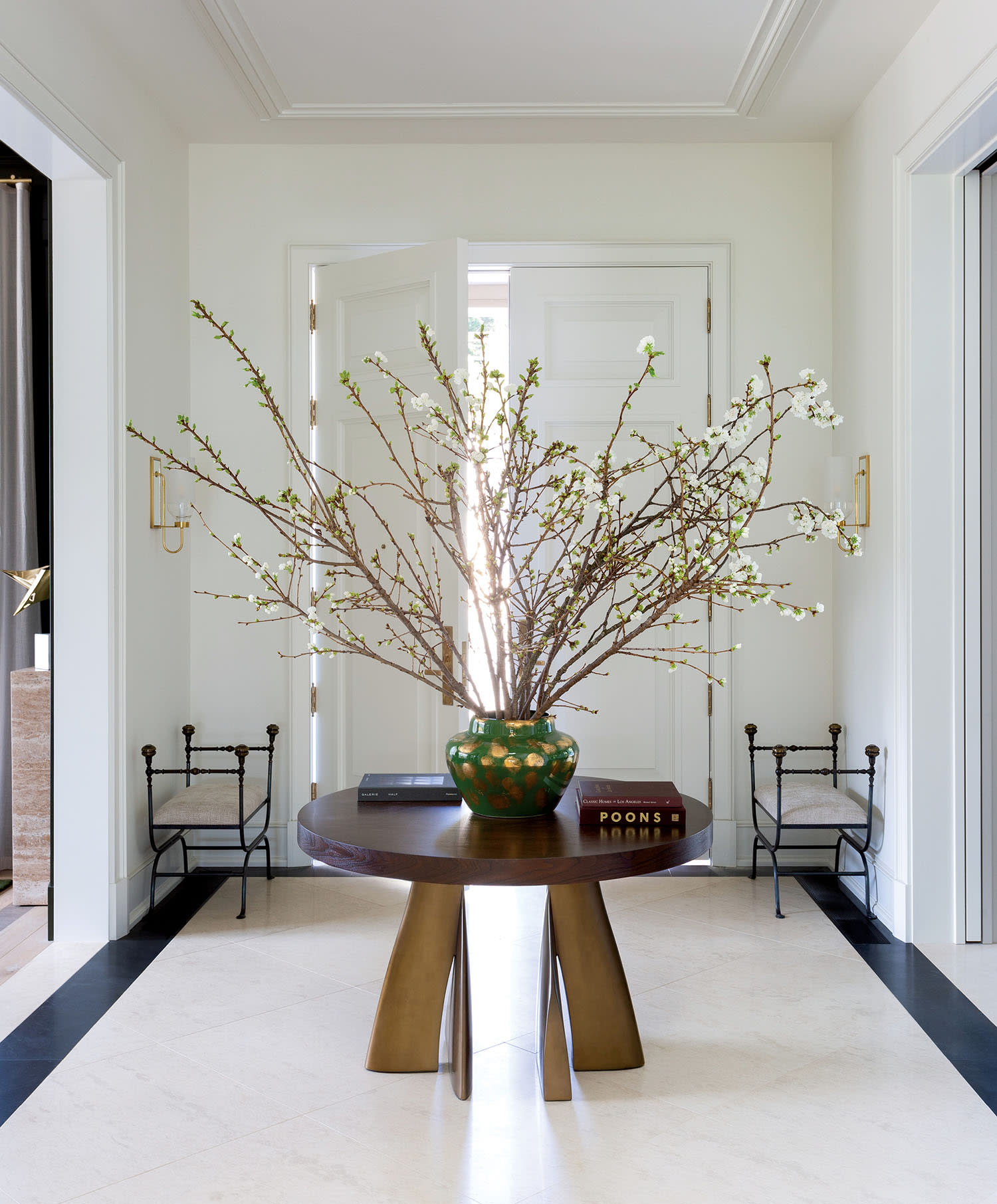 white entry hall with a wood table topped with a floral arrangement