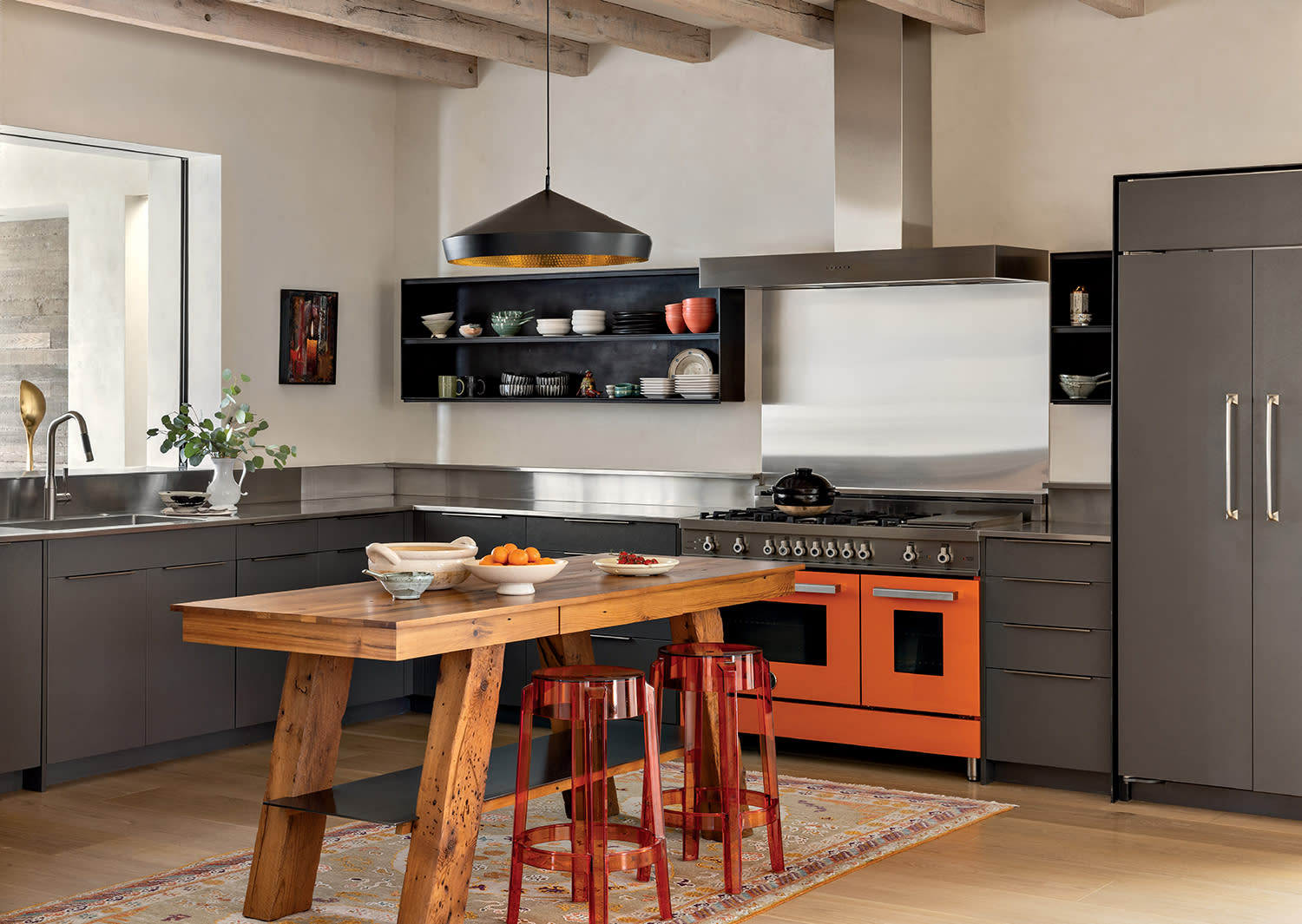 modern Arizona kitchen with steel cabinetry and a wood table for an island