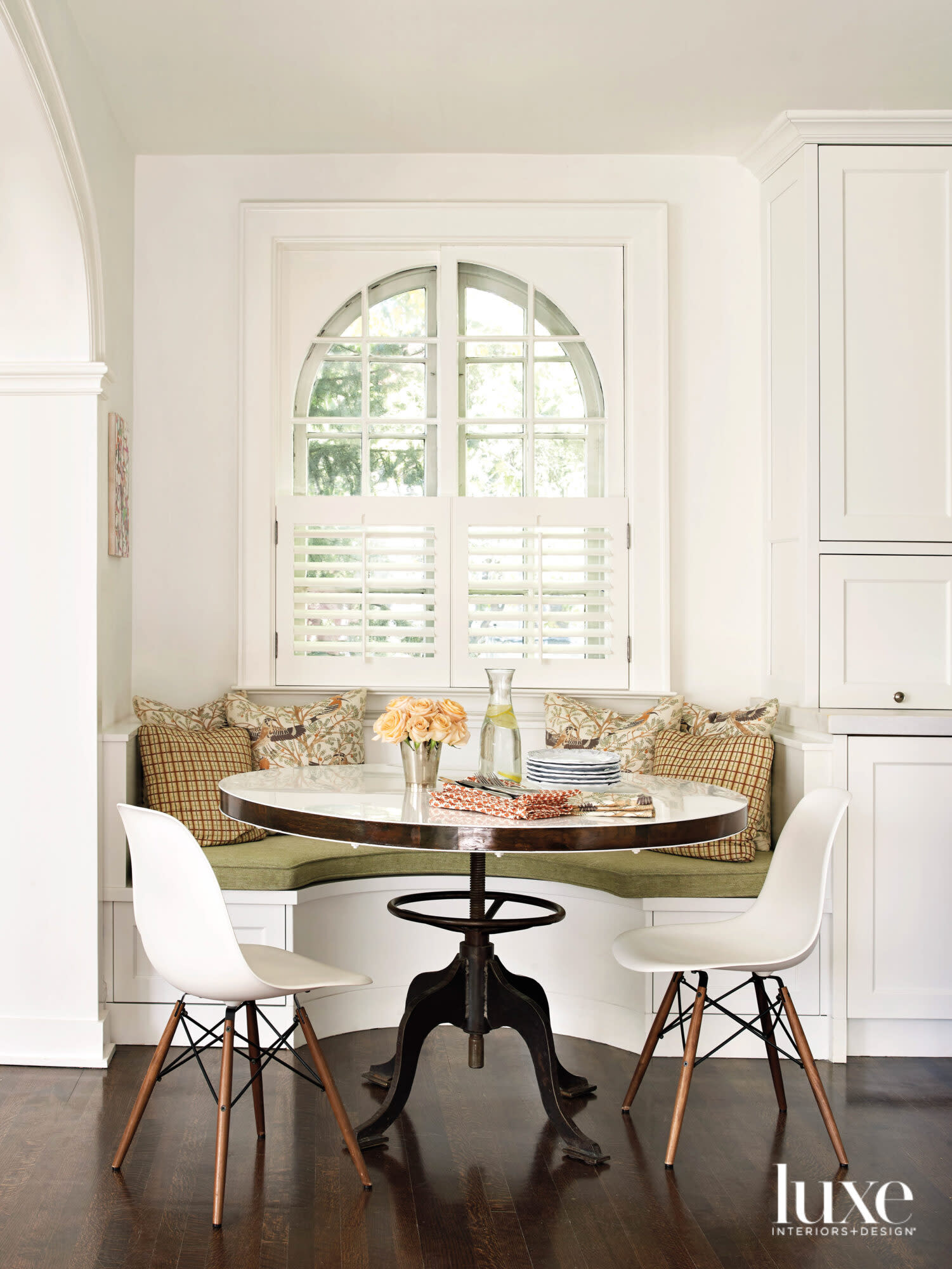 A breakfast nook is nestled against a window.