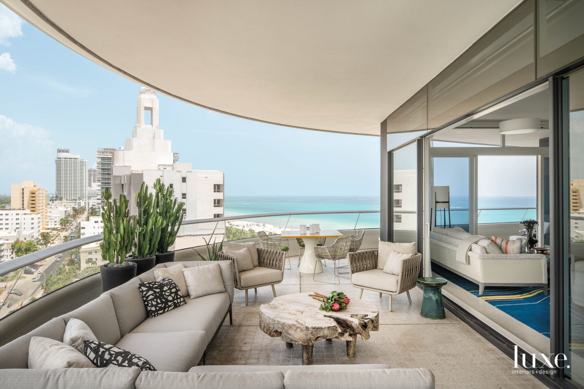 Balcony decorated with wood coffee table with beach and city views