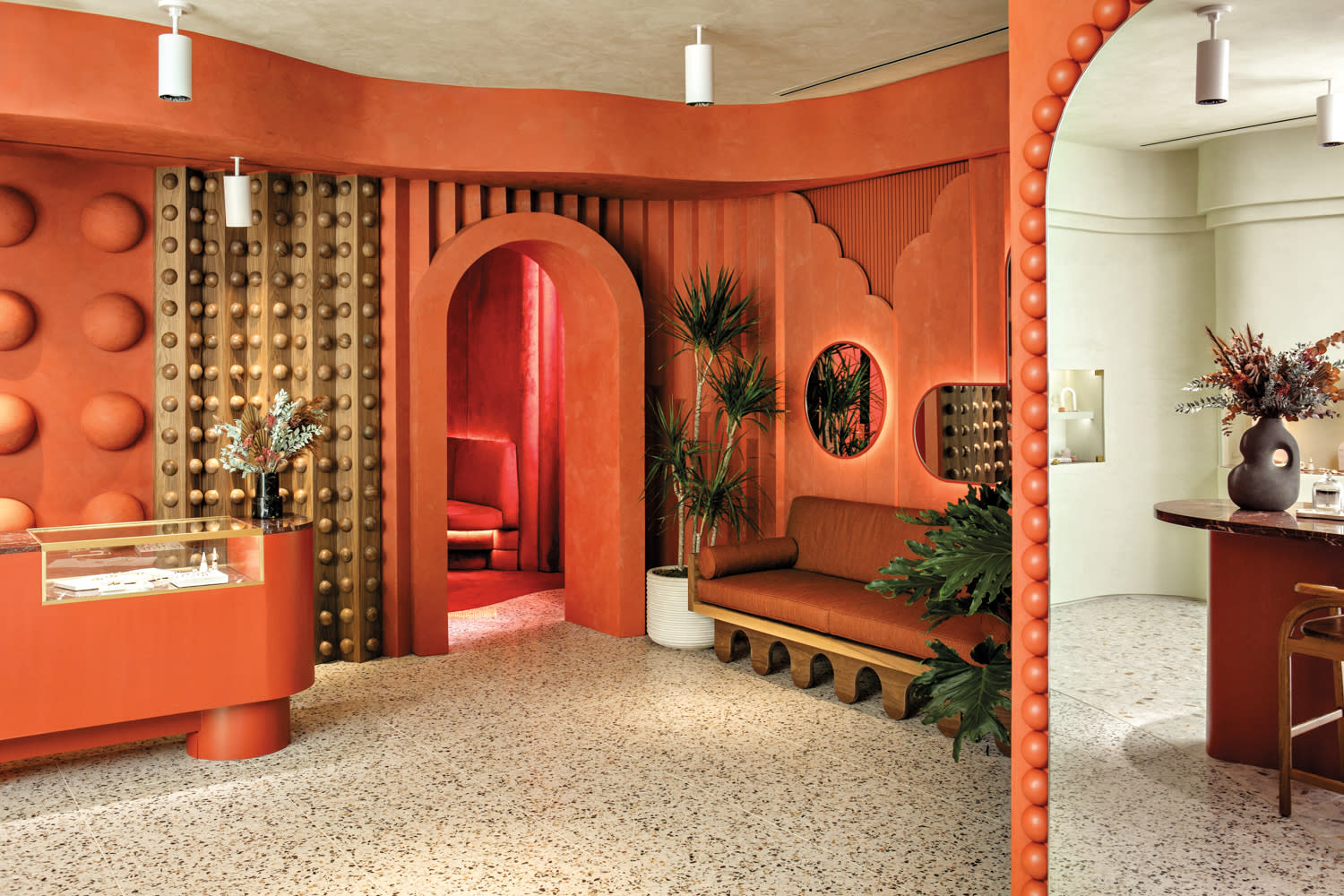 store entry with burnt orange and gold walls and plants