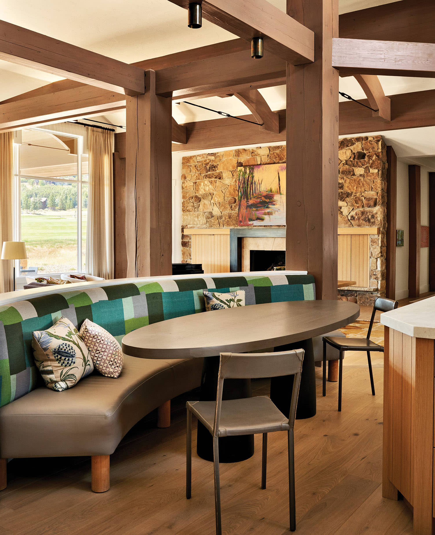 breakfast nook with an oval dining table and a banquette backed by Peter Dunham performance fabric