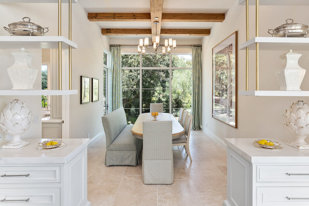 Modern white dining room featuring a table, bench seating and chairs.