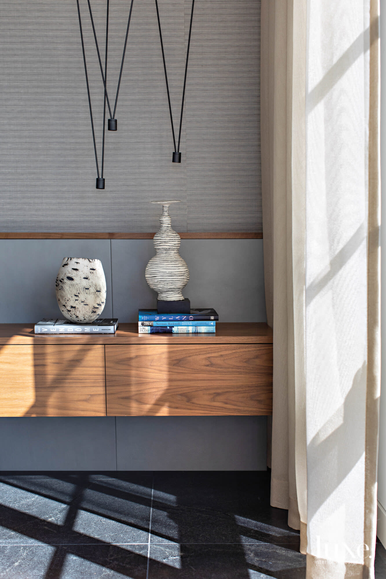 A shelf in the master bedroom with vases and coffee table books.