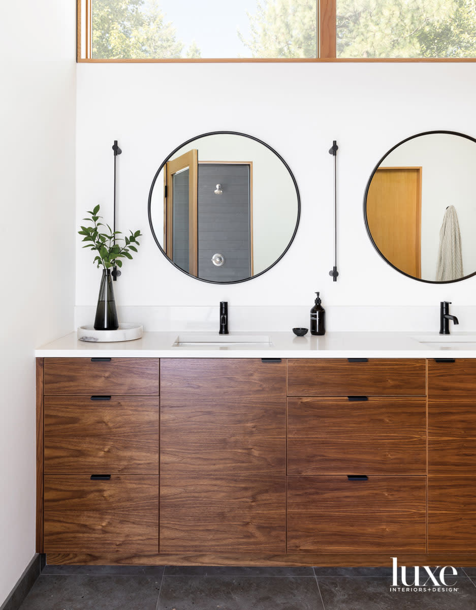 Detail of wood bathroom vanity with a pair of mirrors above