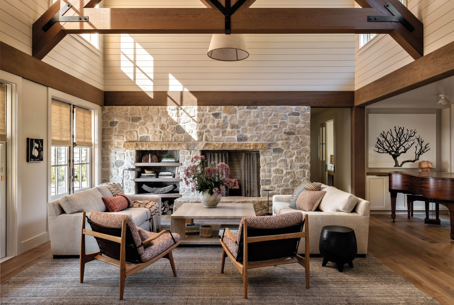 A living room centered around a limestone fireplace wall