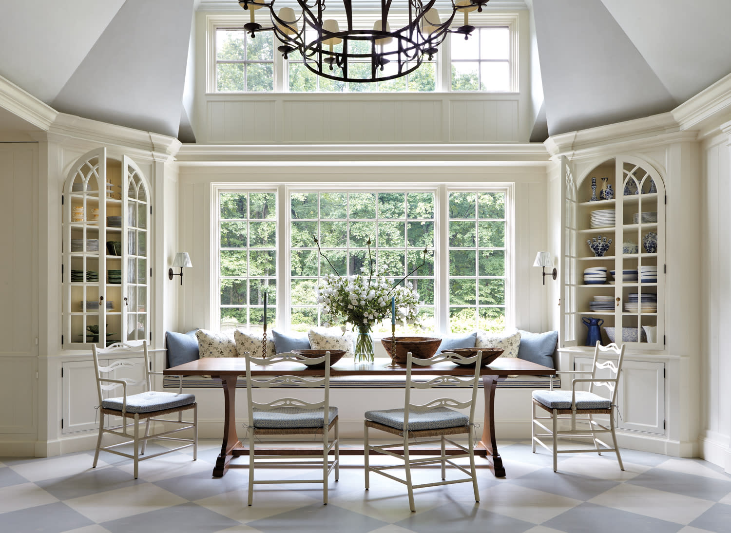 blue and cream breakfast area with iron chandelier in front of windows