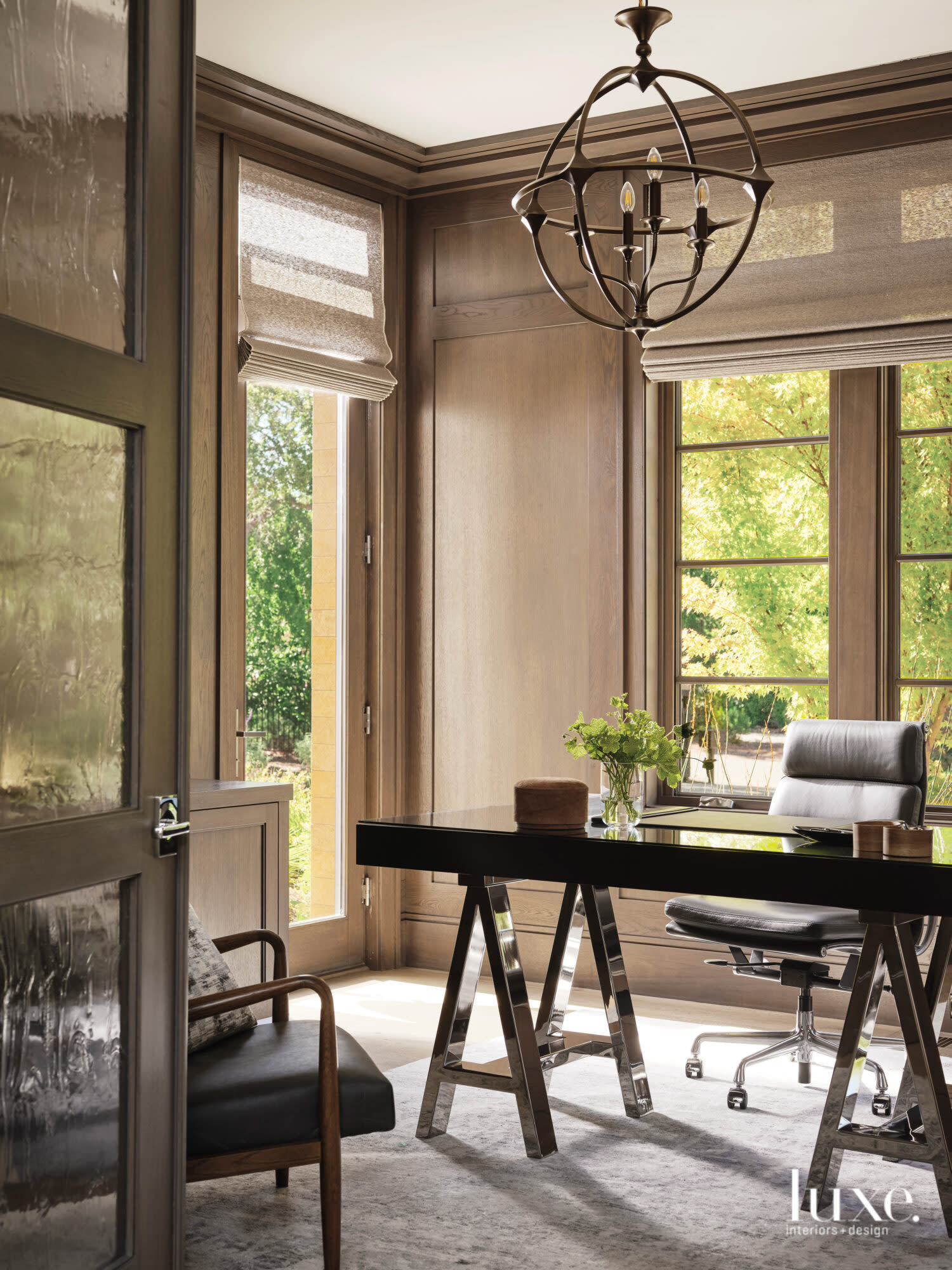 An office has beige walls, and a modern desk and chair.