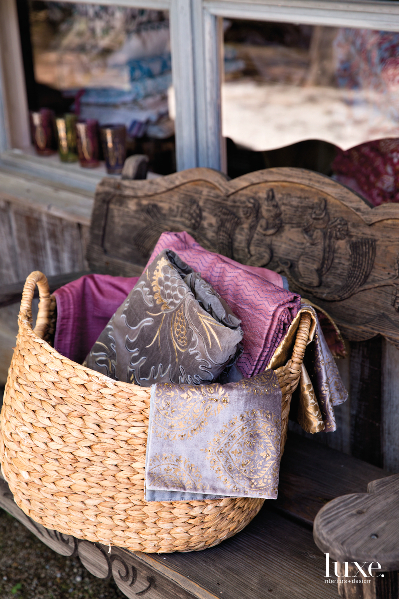 Purple hues are reflected in the fabrics seen in a woven basket.