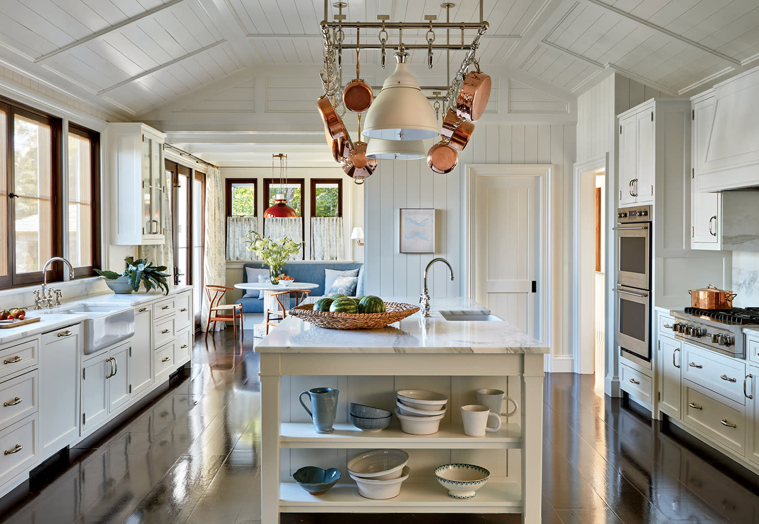 traditional kitchen with glossy brown flooring and white cabinetry
