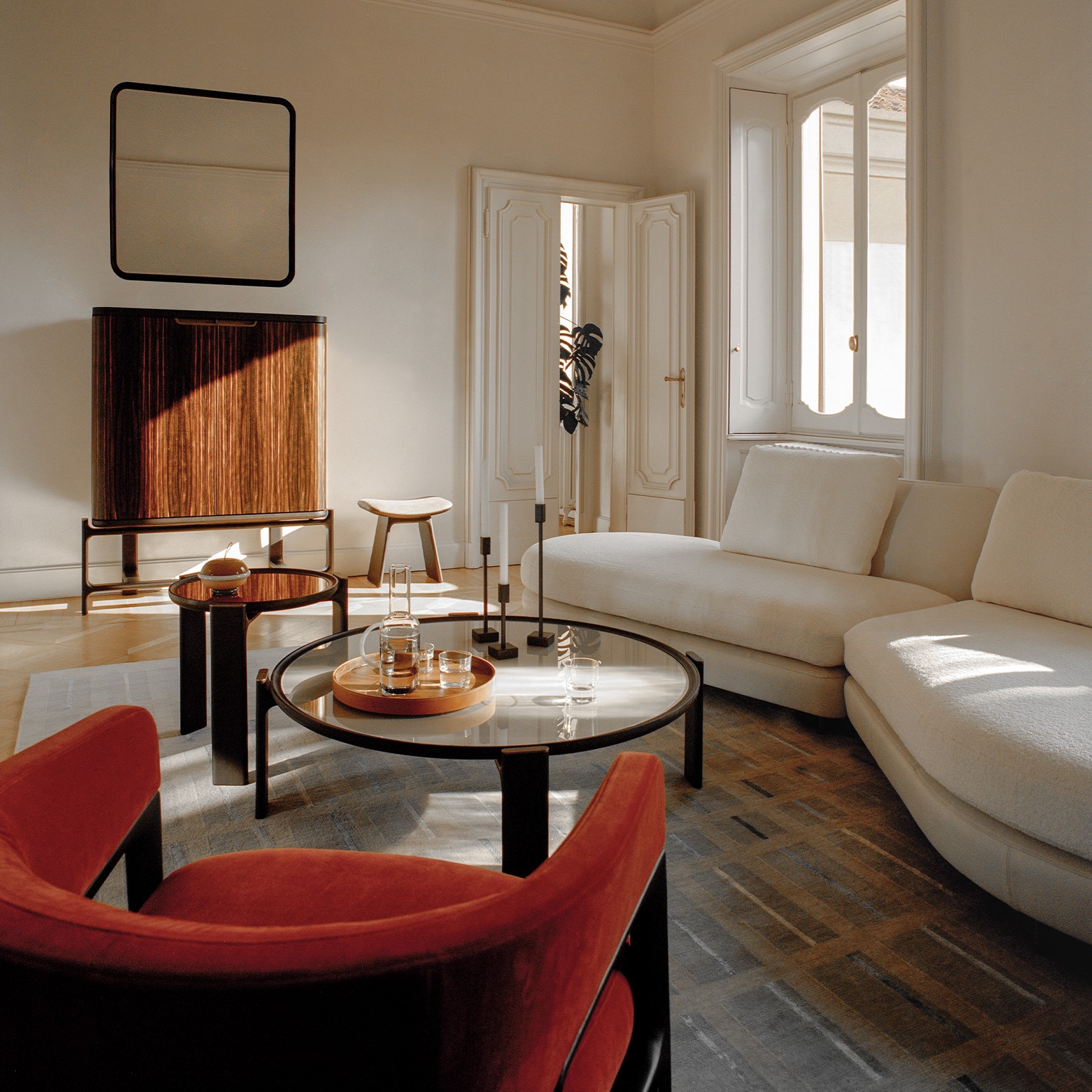 white living room with cream sofa, red armchair and round coffee table