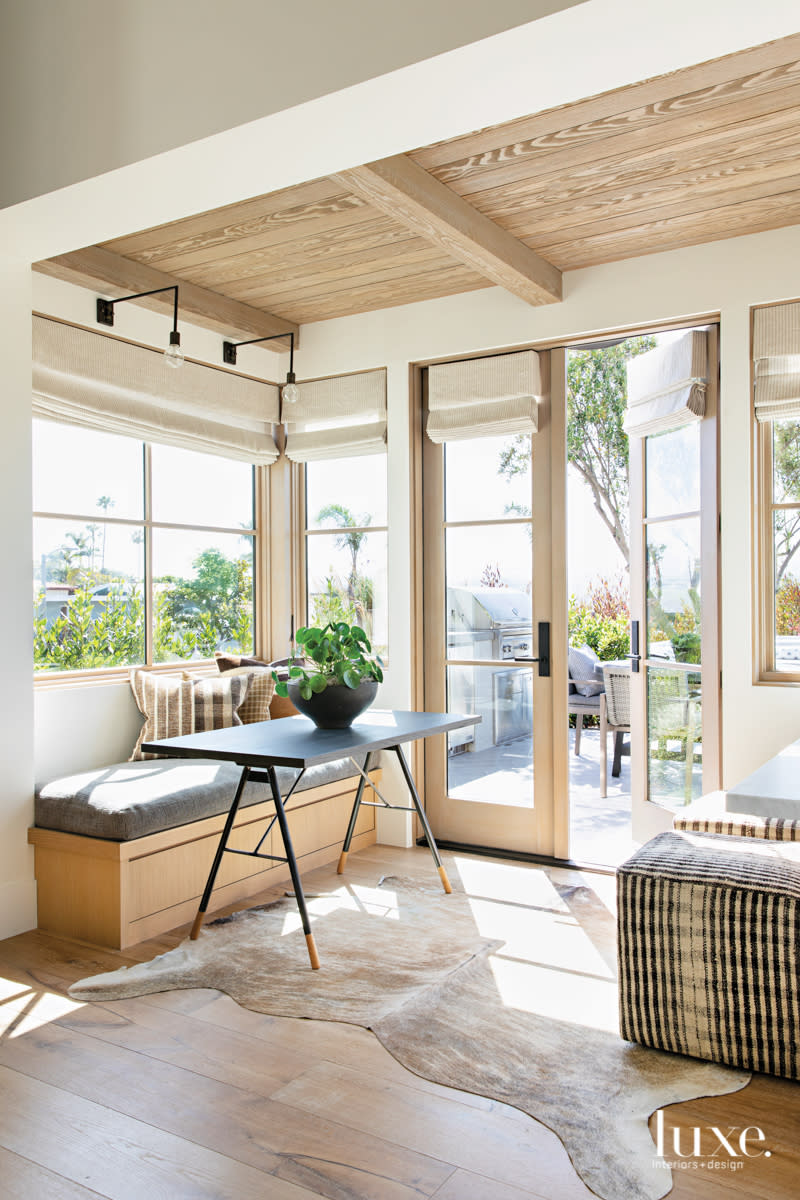 breakfast area with table and bench and window doors to outside