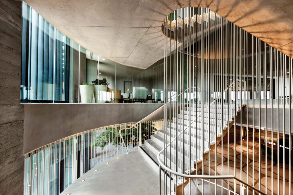 concrete treads and risers and painted-steel rods form the central staircase at the Alila Marea Beach Resort Encinitas 