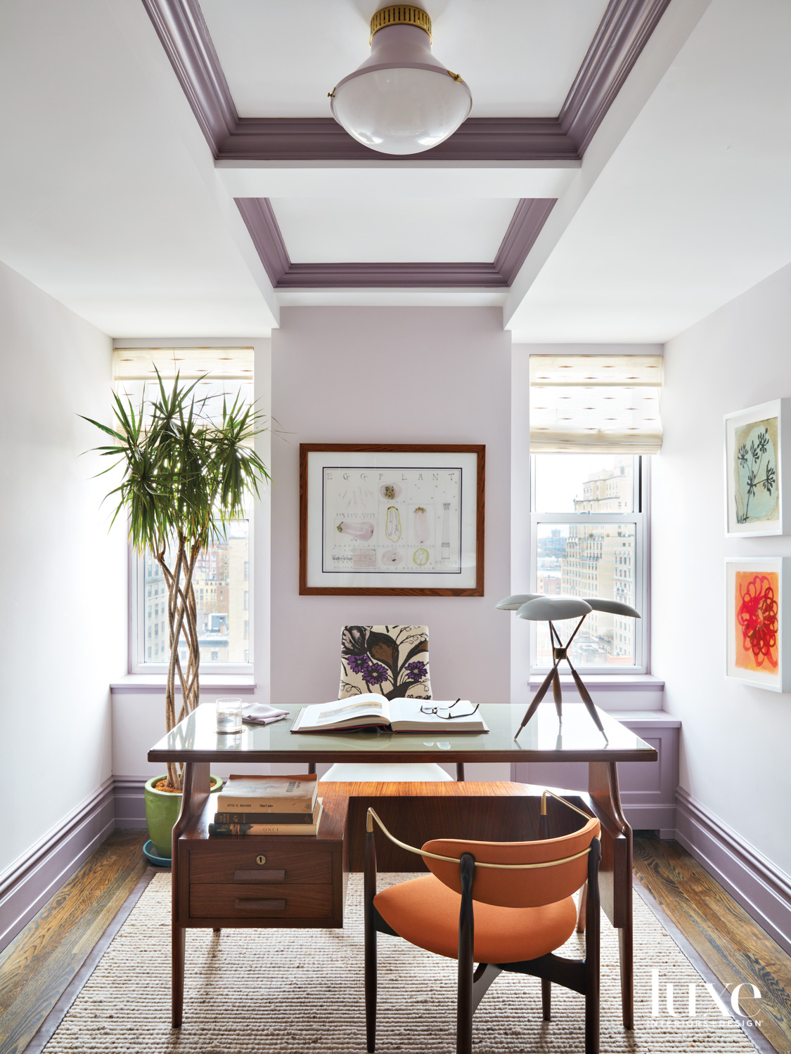 colorful light purple home office with glass desk and orange chair