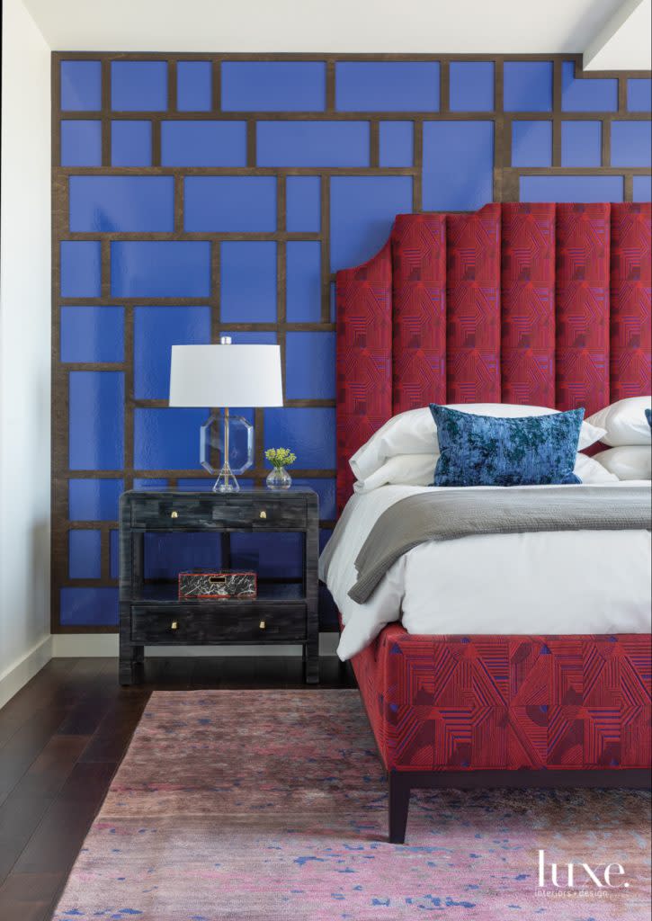 Laser-cut woodwork- lined panels by Post-Studio Projects enhance the master bedroom wallcovering by Phillip Jeffries. The bed upholstered in LelieÌ€vre fabric is a foil for the Made Goods nightstand and Arteriors lamp.